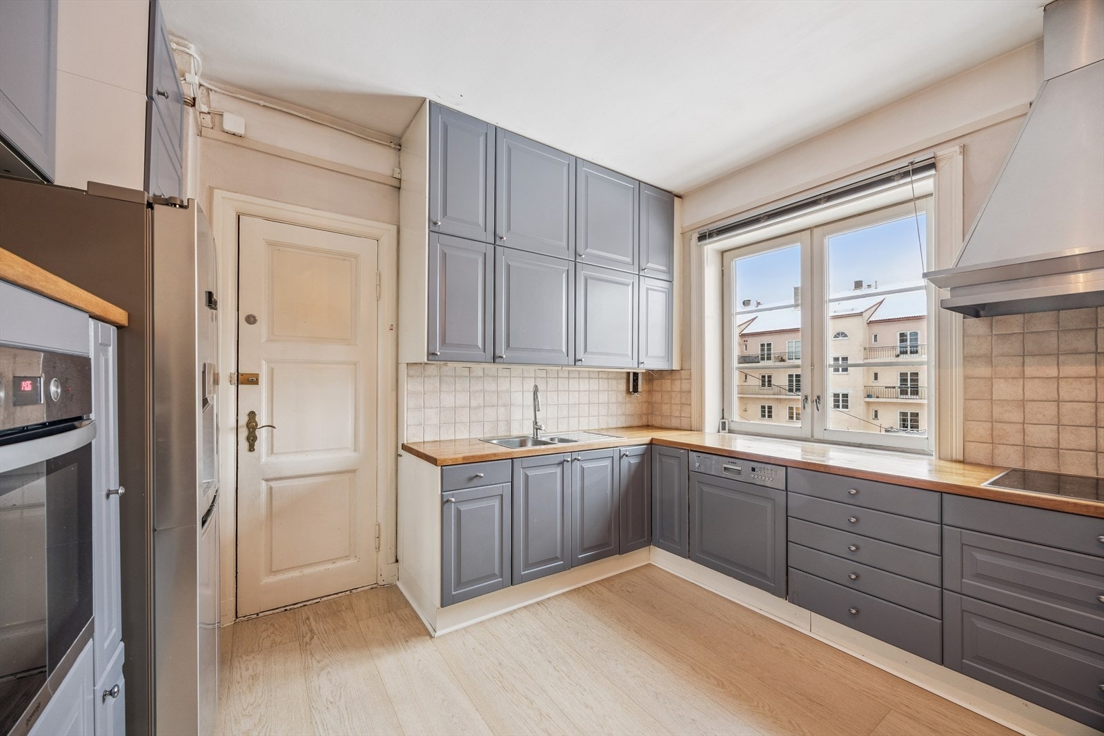 Kjøkken med spiseplass og kjøkkeninnredning m/nedfelt induksjonstopp, integrert oppvaskmaskin og stekeovn. Løst side by side kjøl/frys i egen nisje. Galleribilde