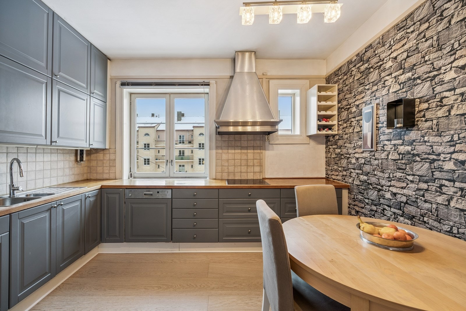 Kjøkken med spiseplass og kjøkkeninnredning m/nedfelt induksjonstopp, integrert oppvaskmaskin og stekeovn. Løst side by side kjøl/frys i egen nisje. Galleribilde