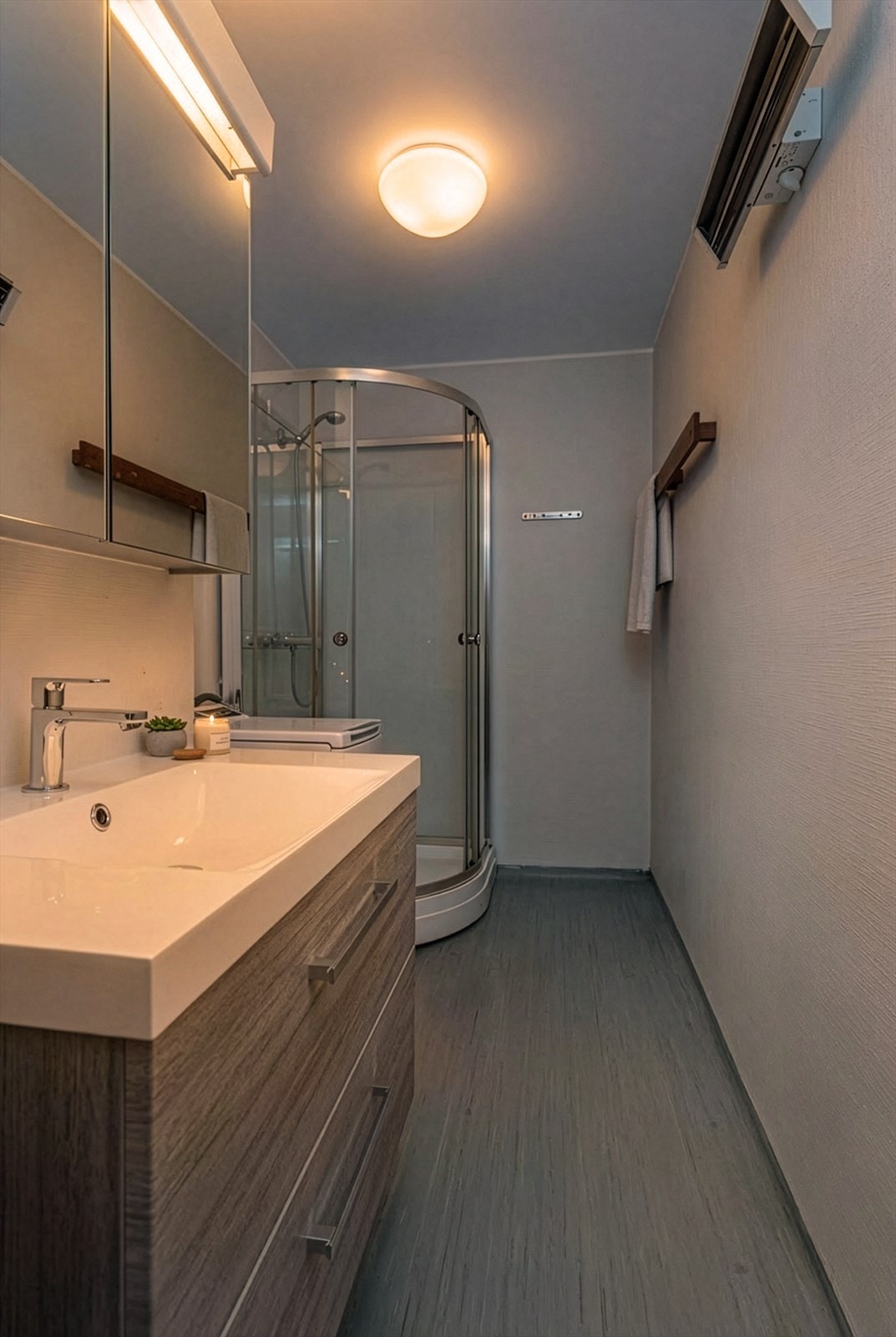 Badet er av eldre dato, men har fått flere oppgraderinger de siste årene. Baderomsinnredningen ble fornyet i 2025 med moderne servantskap med gode skuffer for oppbevaring, samt speilskap som gir ekstra lagringsplass. Galleribilde