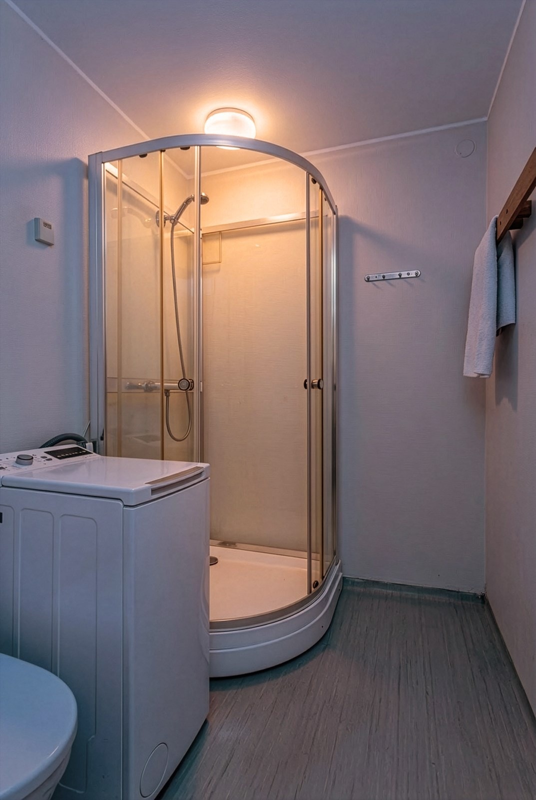 Det er installert nytt toalett i 2024. Badet er ellers utstyrt med dusjkabinett og opplegg for vaskemaskin - en praktisk løsning for en effektiv hverdag. Galleribilde