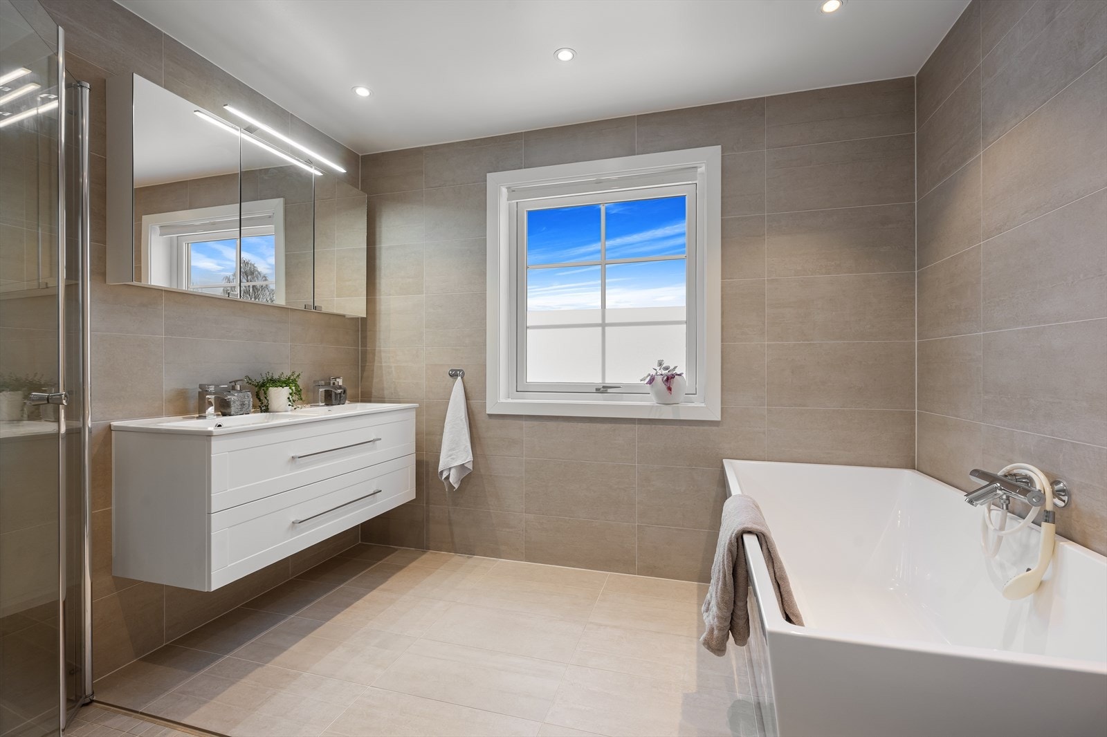 Det romslige hovedbadet i andre etasje ble også renovert i 2017 med downlights, fliser med varme i gulv og innredning. Galleribilde