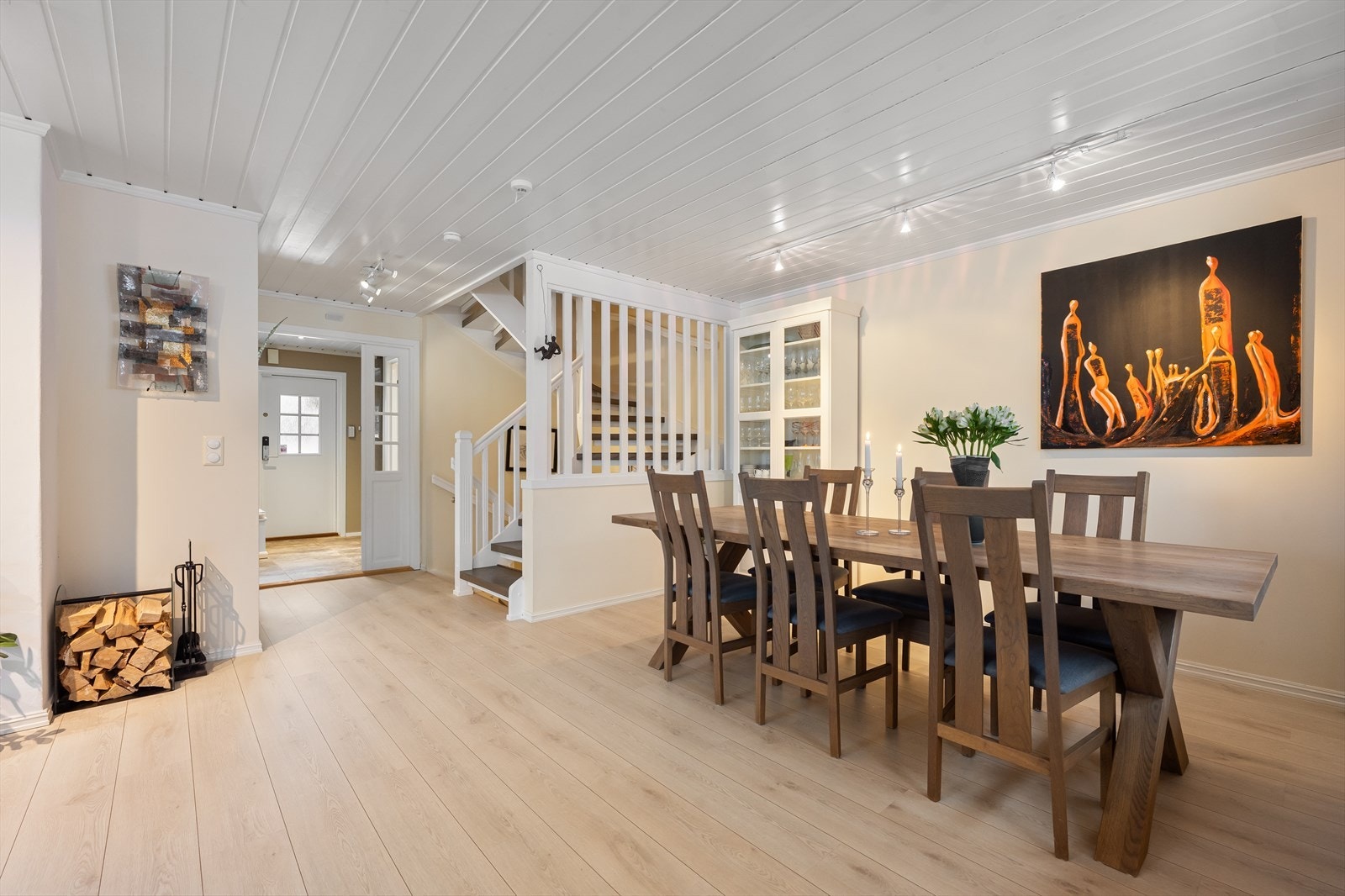 Stue med spiseplass er romslig med lekkert lyst gulv. Overflater er malt i varme, lyse toner. Galleribilde