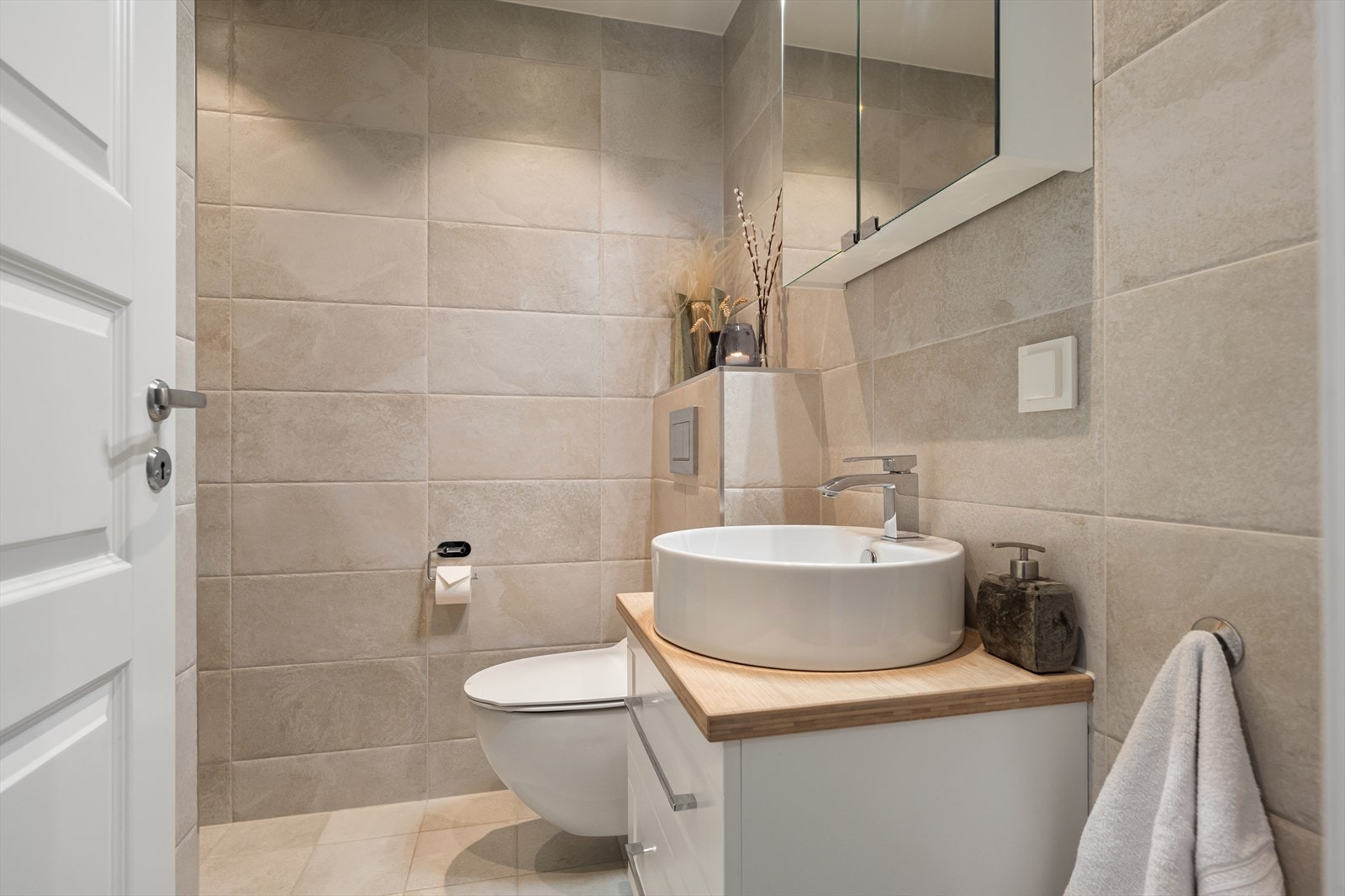 Tidløst og moderne bad i første etasje som ble renovert i 2017 med vegghengt toalett og en moderne bollevask. Galleribilde