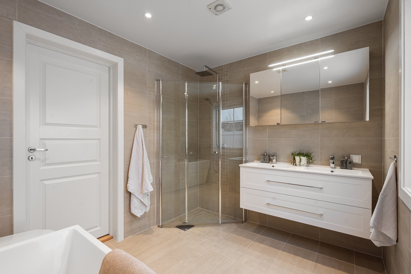 Flott moderne bad fra 2017 som er fagmessig utført. Her har du både badekar, dusj og dobbelservant med innredning. Galleribilde