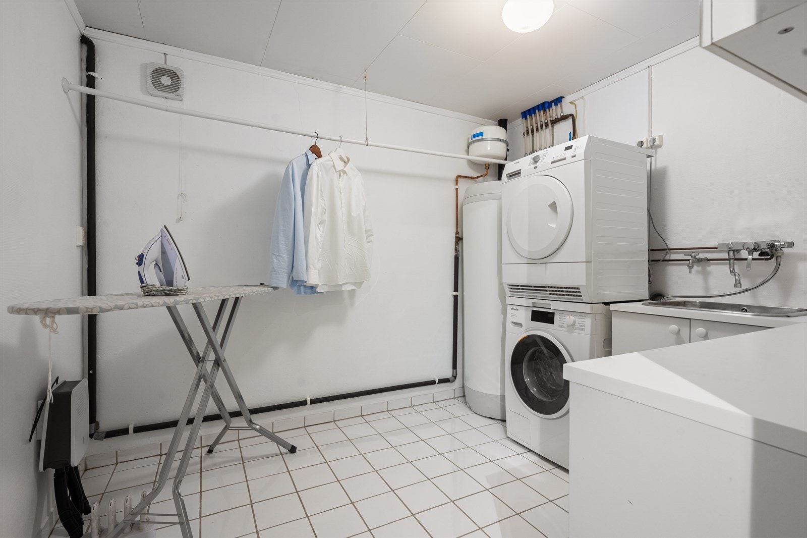 Funksjonelt vaskerom fra 1998 med flislagt gulv, opplegg for vaskemaskin og en nyere varmtvannsbereder fra 2017. Galleribilde