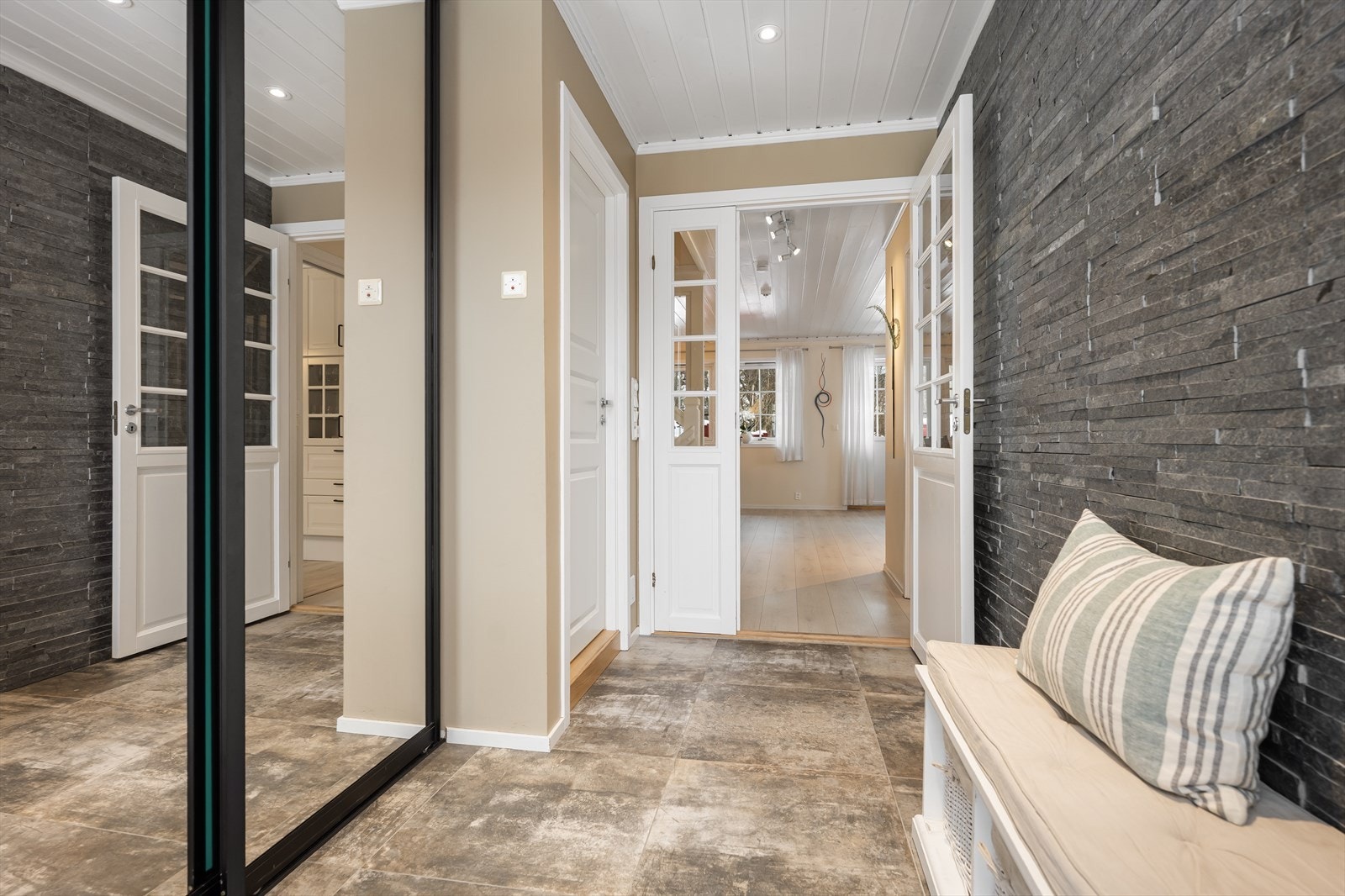 Entréen har god plass og en praktisk skyvedørsgarderobe med speilfronter. Fliser med varme i gulvet. Galleribilde