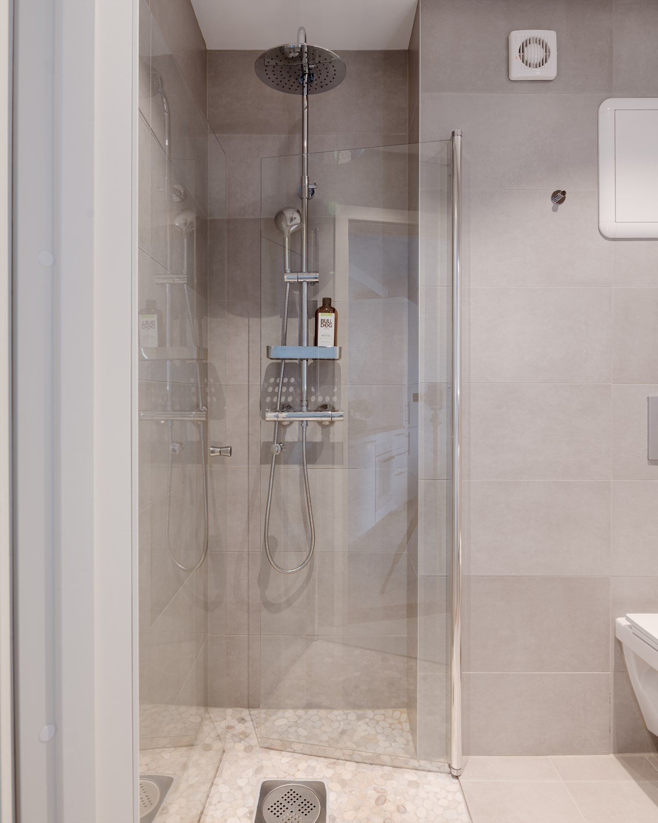 Det er et dusjhjørne med glassdører. Gulvet har termostatstyrte varmekabler som gir en behagelig start på dagen, og himlingen er nedsenket med innfelte downlights. Galleribilde