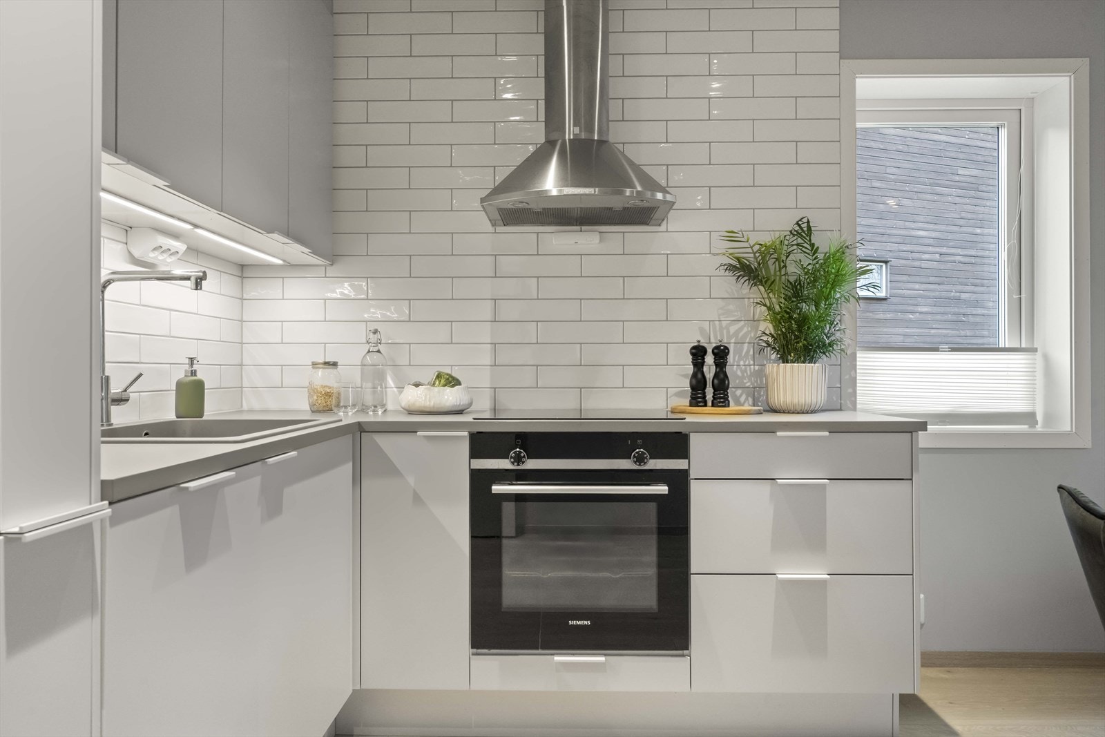 Det er lagt flisar på store veggflater over kjøkkenbenken. Galleribilde