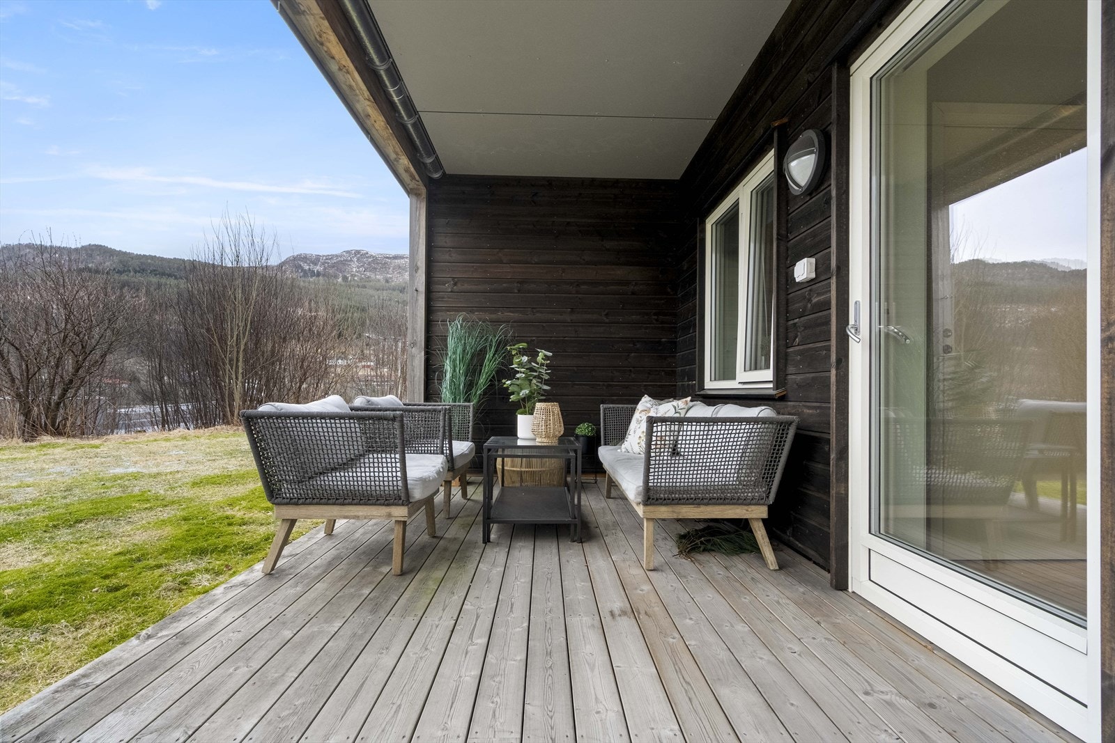 Frå stova ledar glassdør ut til romsleg og overbygd terrasse. Galleribilde