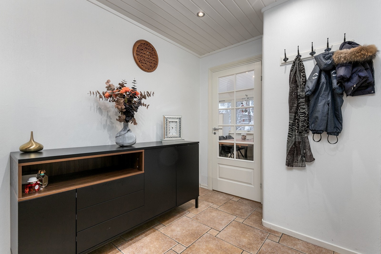 Flislagt entré med lysmalte veggflater. Himlingen er lyssatt med downlights. Galleribilde