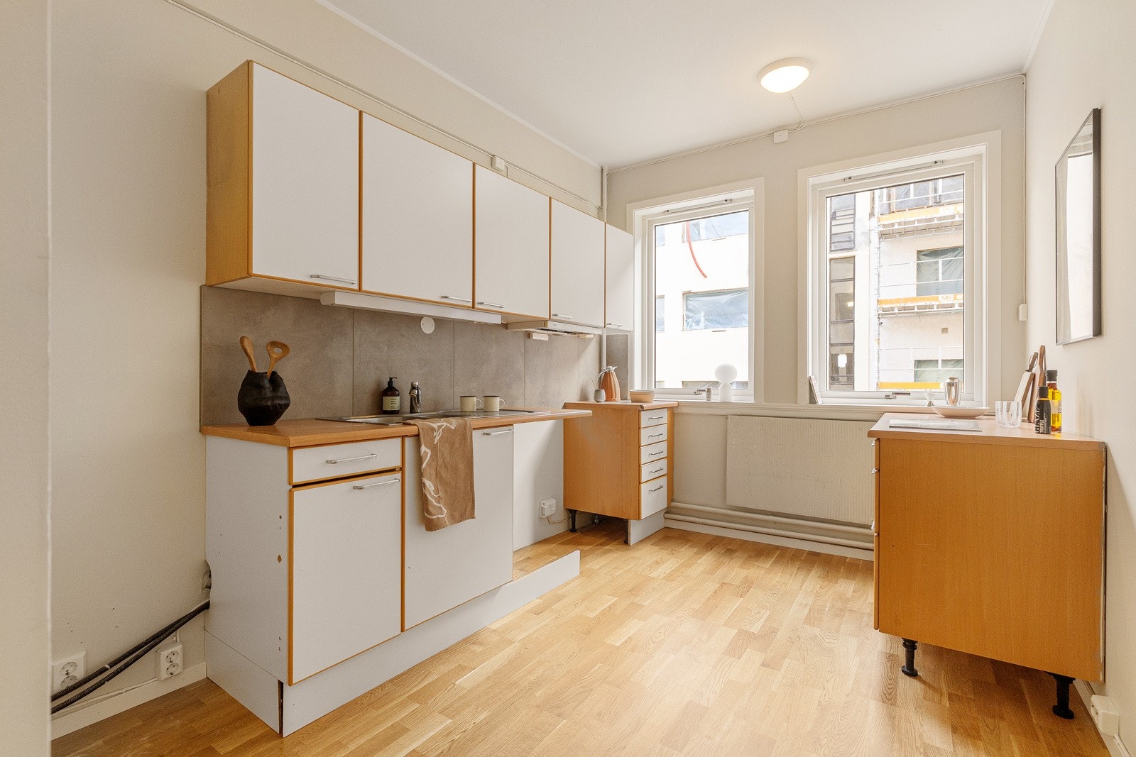 Separat eldre kjøkkeninnredning med glatte hvite fronter, laminatbenkeplate med nedfelt 1,5 vaskekum og ettgreps krummet armatur Galleribilde