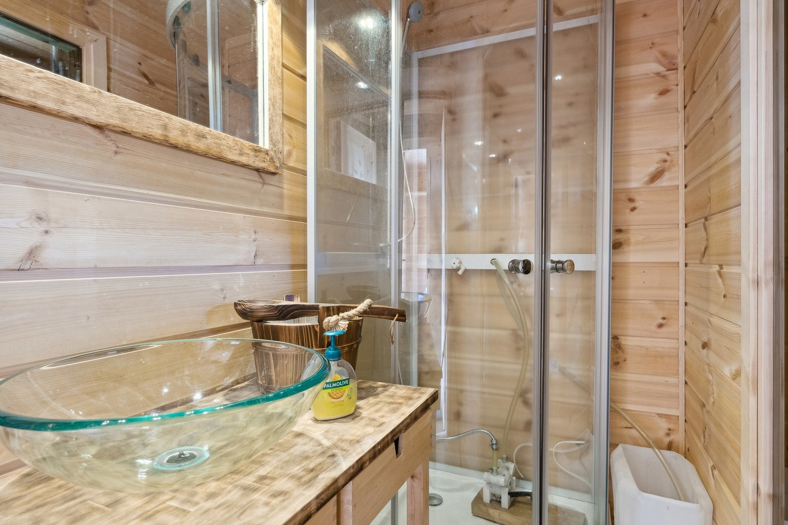 Dusjrom har heltregulv, trepanel på gulv og vegger. Montert dusjkabinett med tråpumpe og vann fra bøtte. Servantskål for hygieniskbruk og vaskevann. Galleribilde