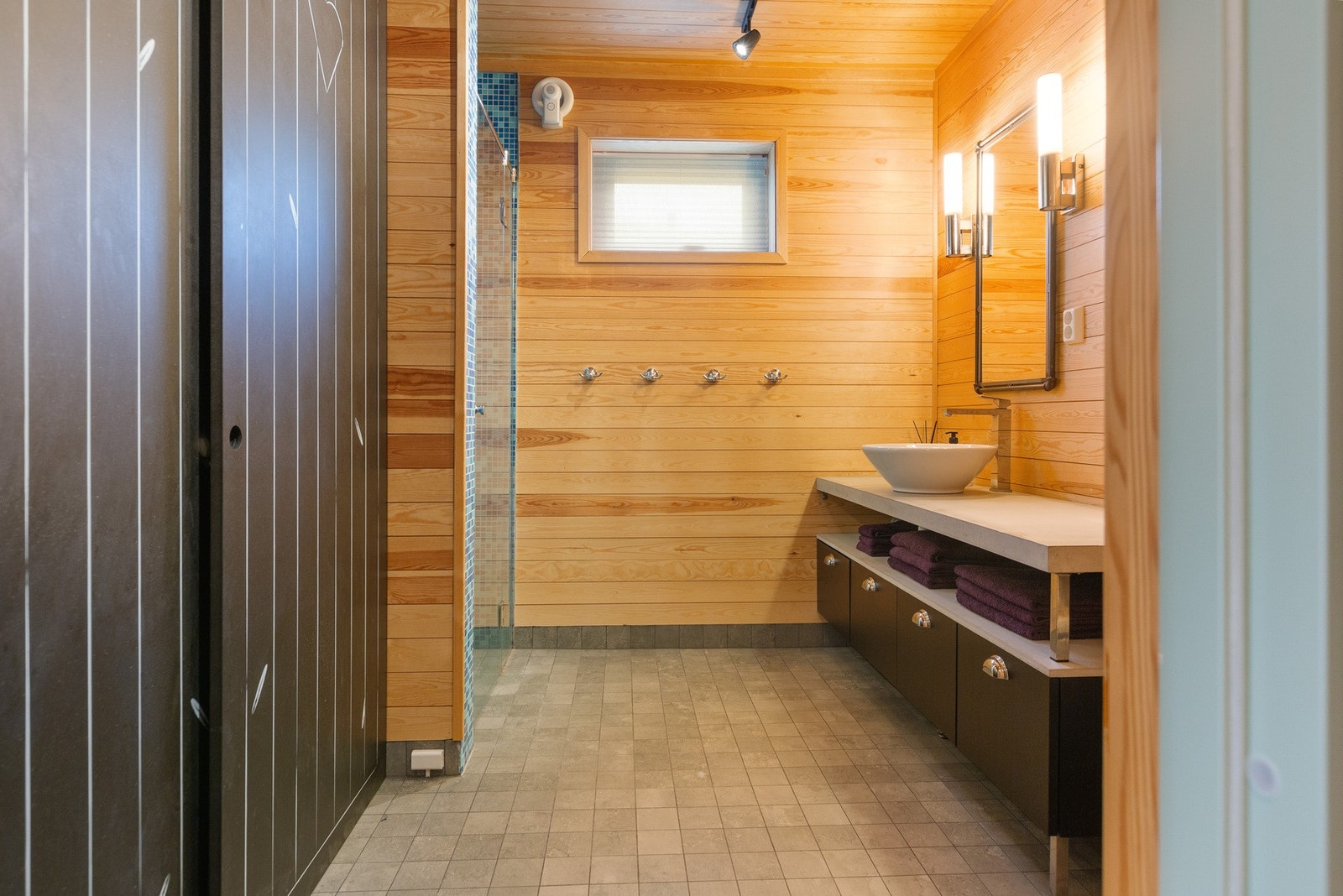 Bad med dusjnisje, servant med underskap og vegghengt toalett. Galleribilde