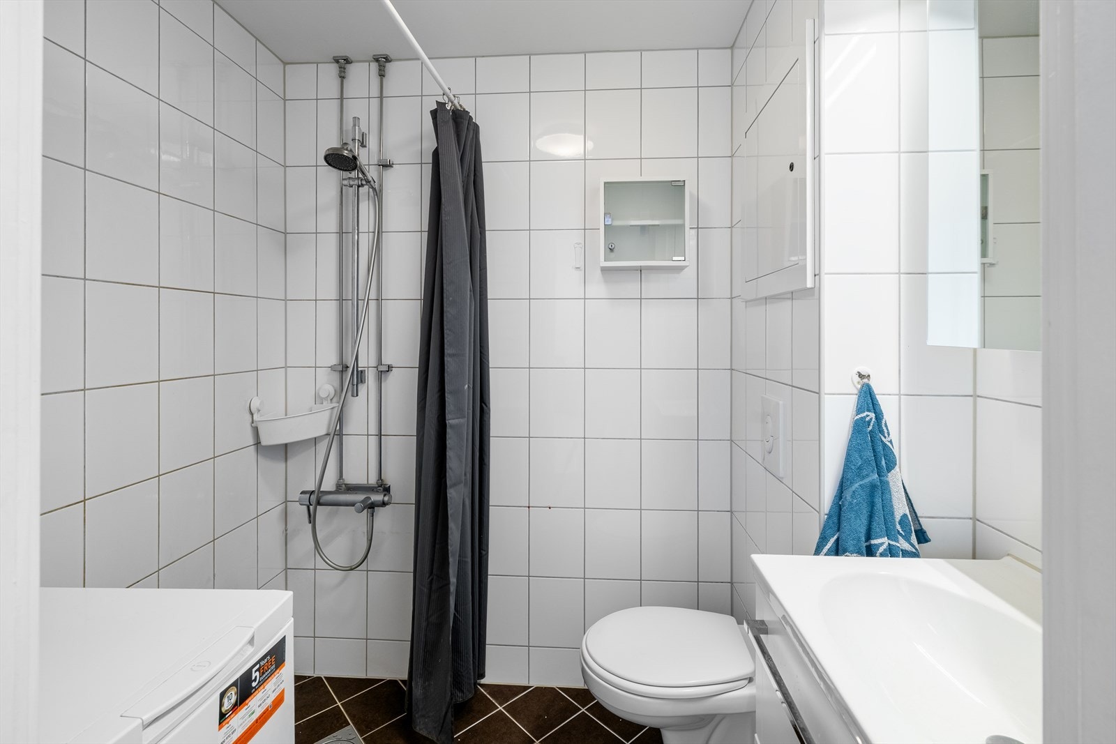 Lyst og fint flislagt bad med gulvvarme og opplegg for vaskemaskin Galleribilde