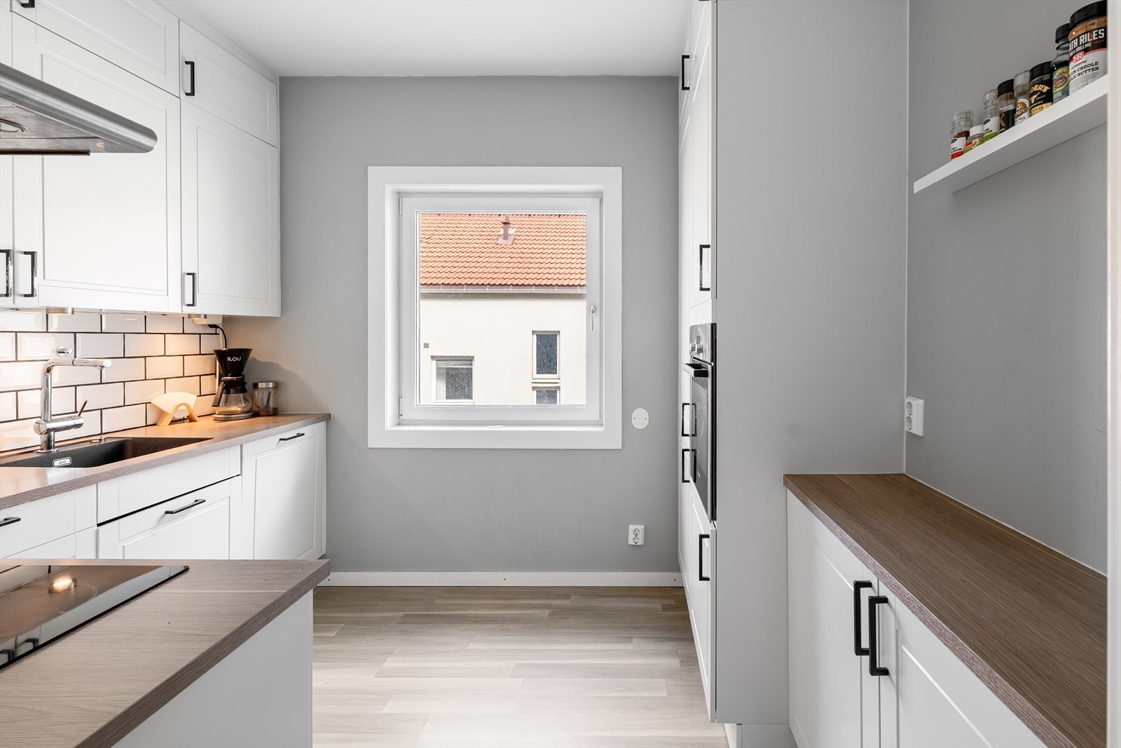 Lekker kjøkkeninnredning fra HTH med hvite profilerte fronter og belysning under skapene Galleribilde