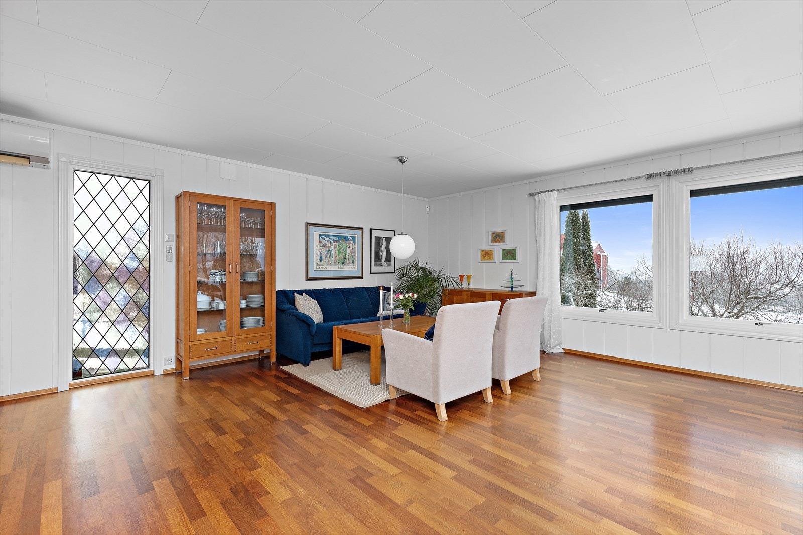 Store vindusflater gir rikelig med naturlig lys inn i stuen. Galleribilde