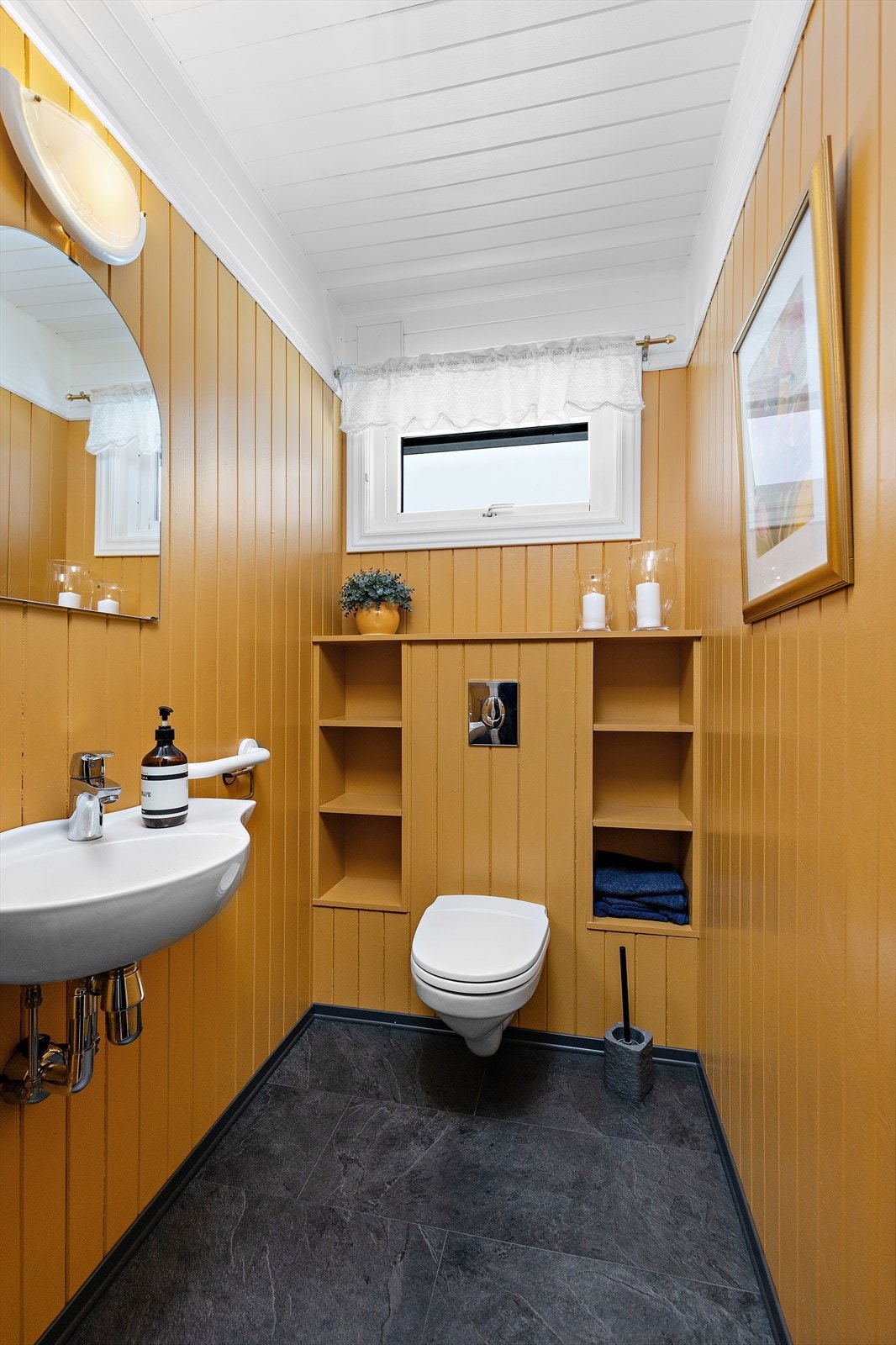 Praktisk, separat toalettrom med vegghengt toalett og smarte, innebygde hyller. Galleribilde