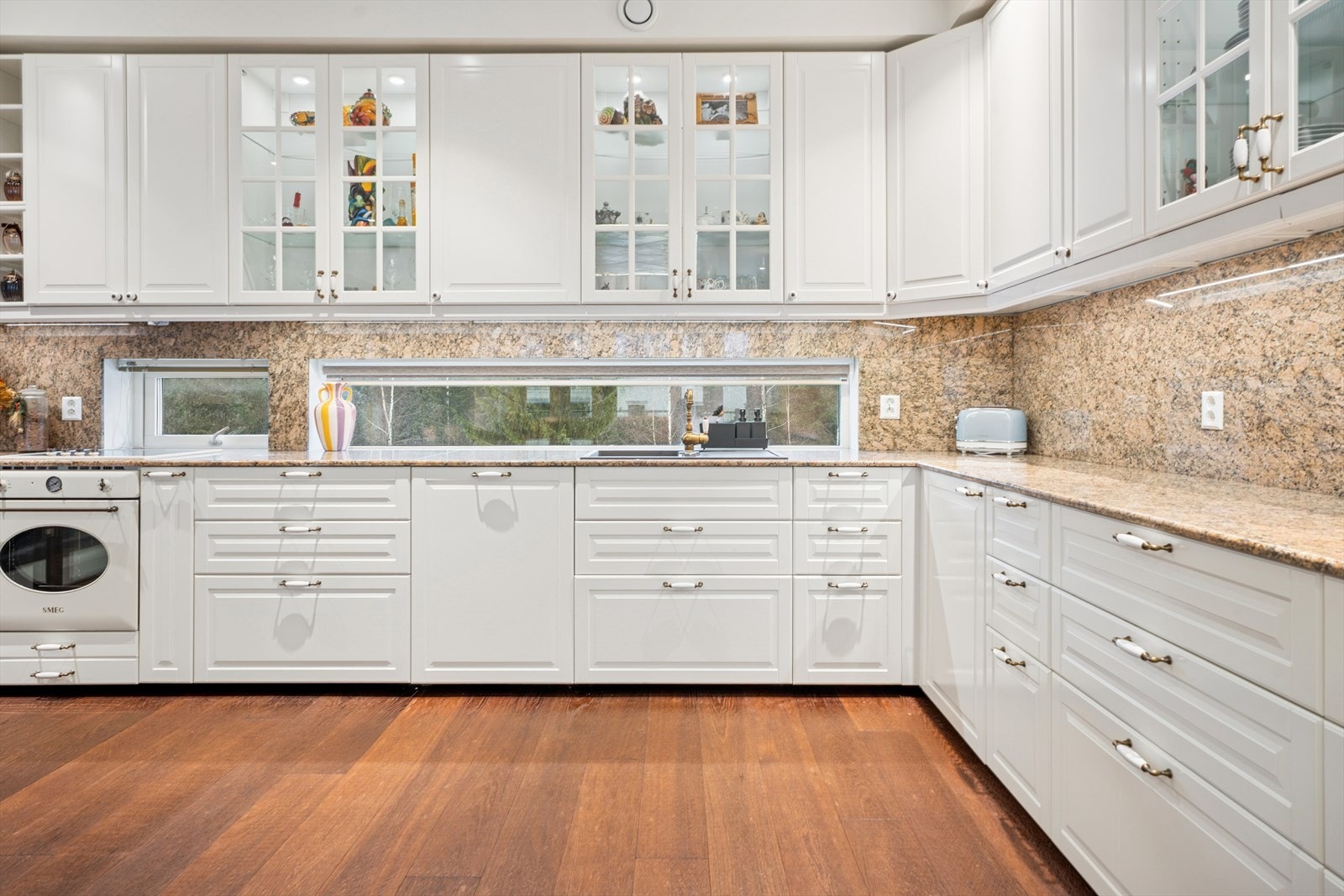 Både benkeplaten og veggen mellom over- og underskap er kledd i polert granittstein. Galleribilde