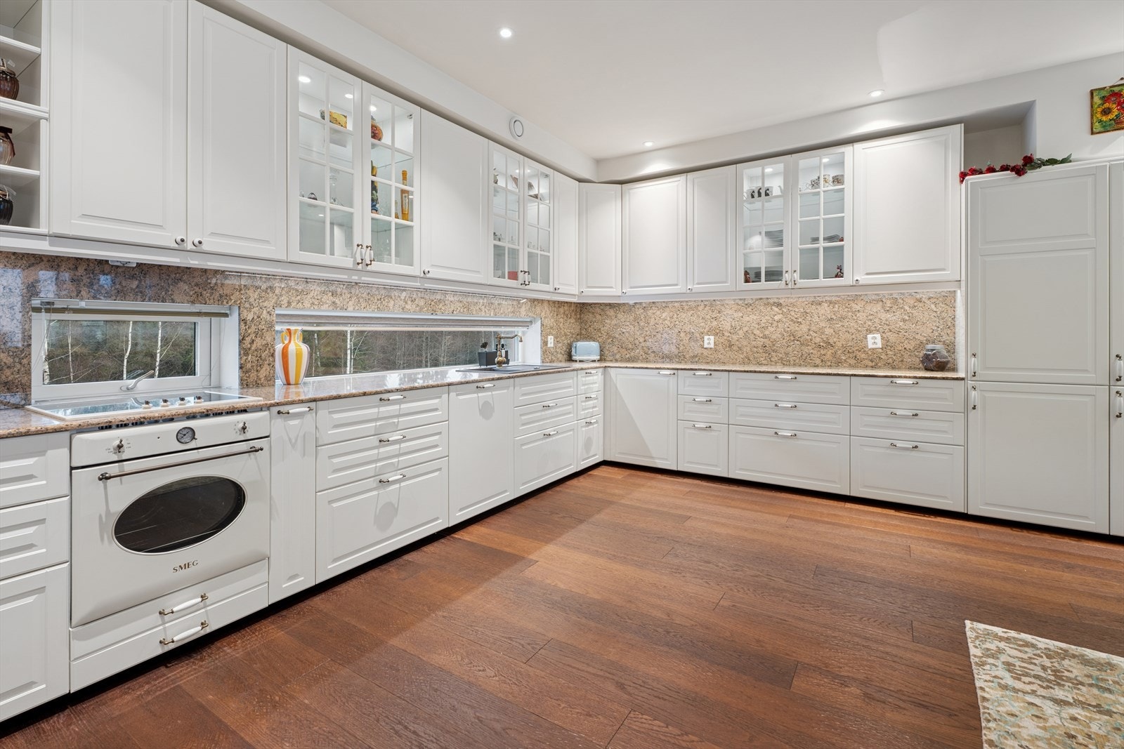 Kjøkkenet har en takhøy innredning med profilerte fronter og vitrineskap. Galleribilde