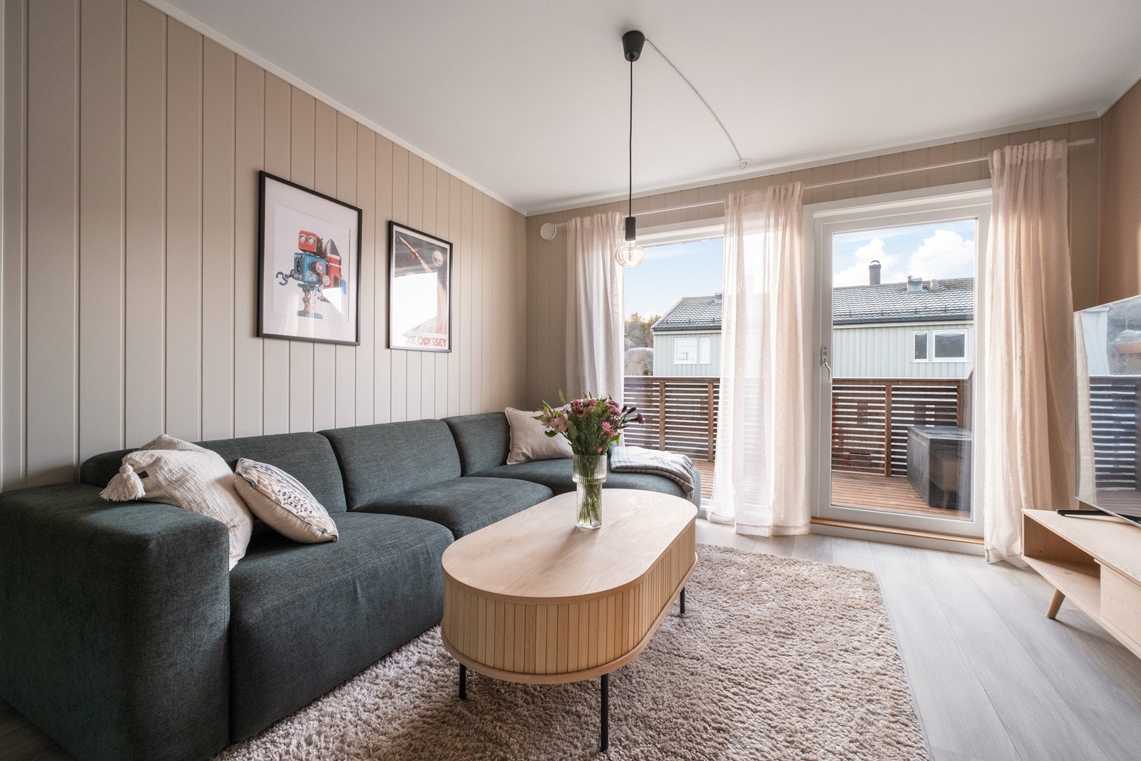 Laminatgulv og malte veggplater gir stuen et stilrent preg, og de store vinduene slipper inn godt med dagslys. Galleribilde