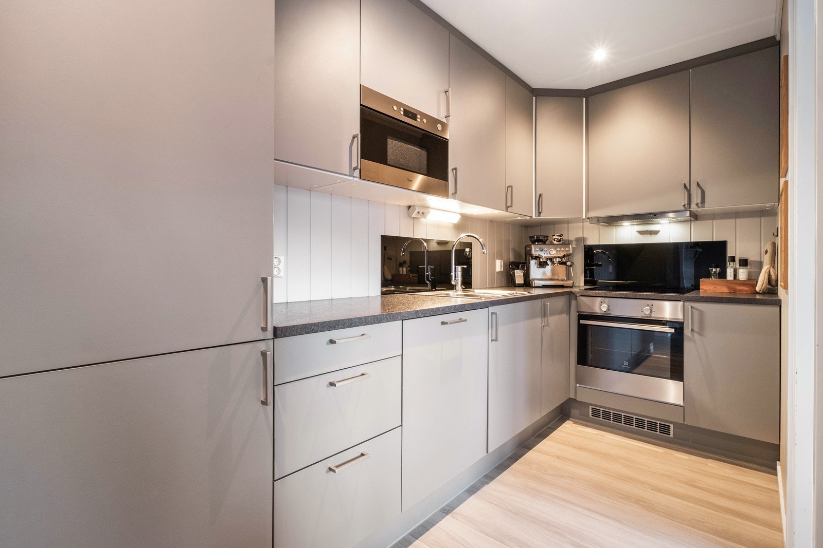 Kjøkkenet har glatte fronter i tidløs design og integrerte hvitevarer. Galleribilde