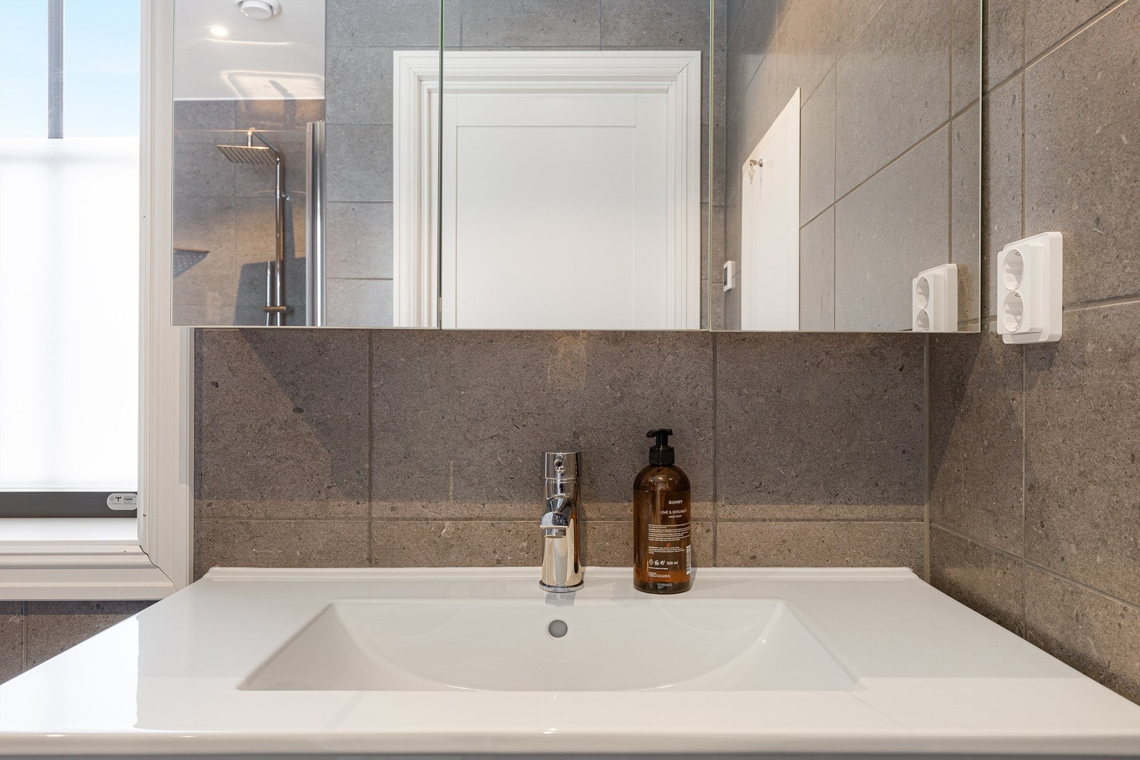 Et stort speilskap med integrert belysning gir godt lys og ekstra oppbevaring. Galleribilde