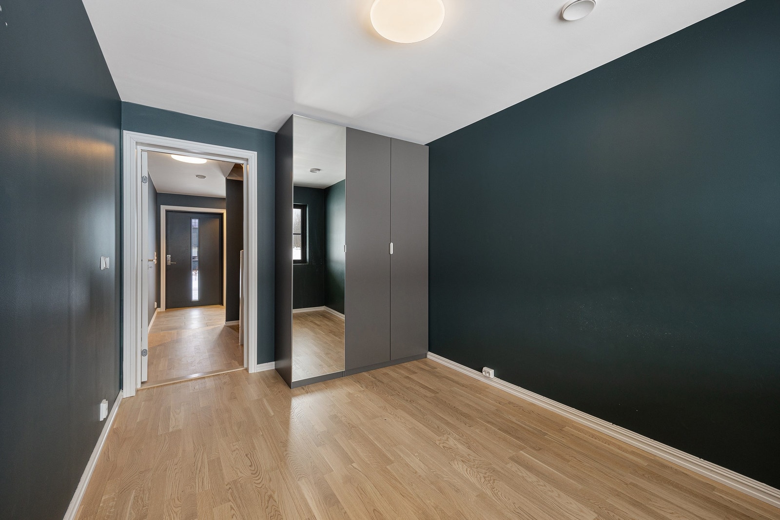 Et stort garderobeskap med speilfronter gir rikelig med oppbevaringsplass. Galleribilde