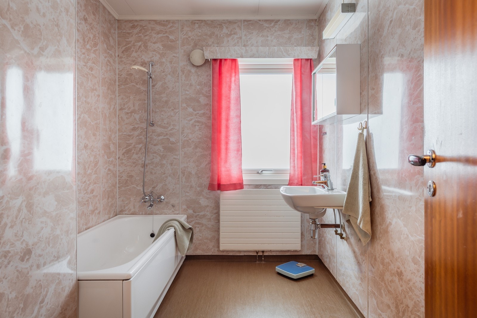 Bad med tilkomst fra mellomgang. I rommet er det enkel vaskeservant, gulvmontert wc og badekar. Galleribilde