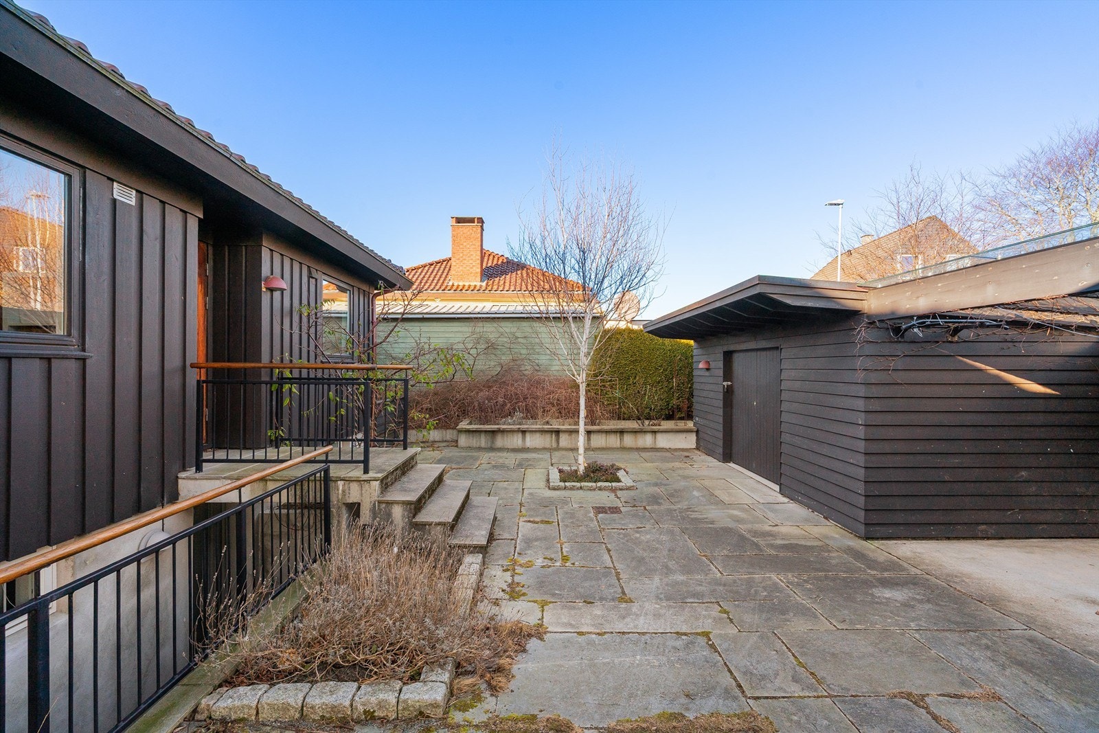 Stort gårdsrom med biinngang, utebod, søppelskur, samt carport. Galleribilde