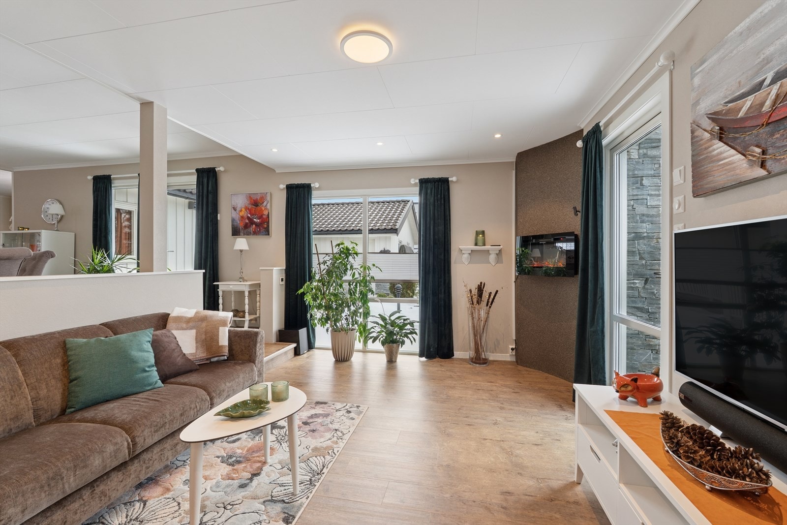 Fra stuen er det utgang til en av eiendommens solrike terrasser. Galleribilde