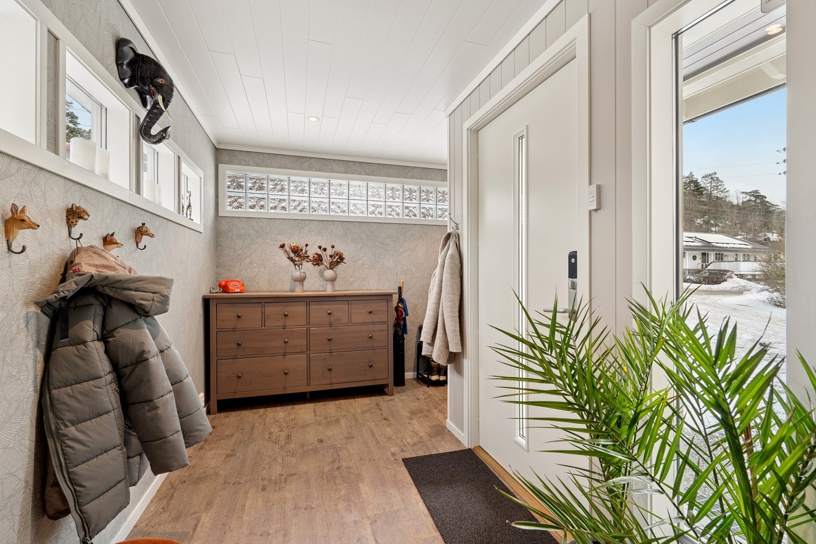 Romslig og lys entré med god plass til oppbevaring av yttertøy og sko. Galleribilde