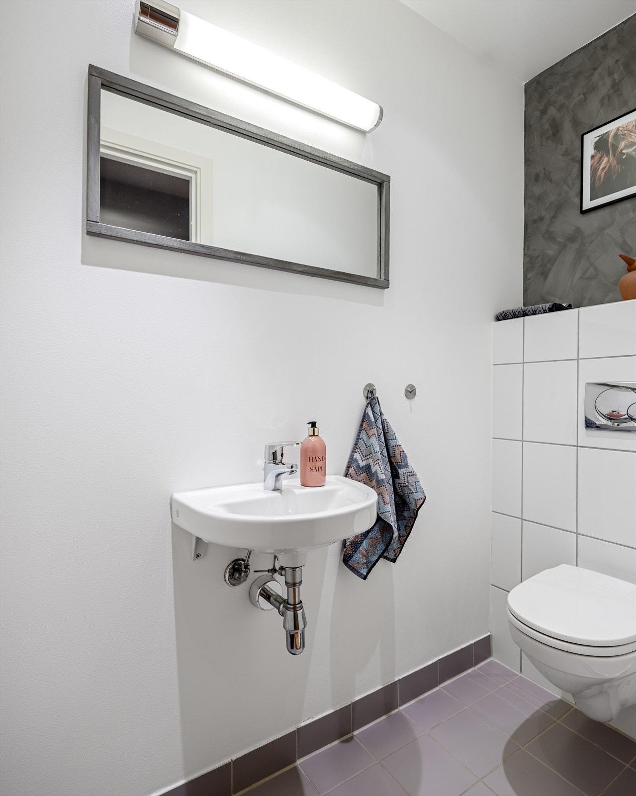 Separat wc-rom/gjestetoalett med flislagt gulv, elektriske varmekabler og malte veggflater Galleribilde