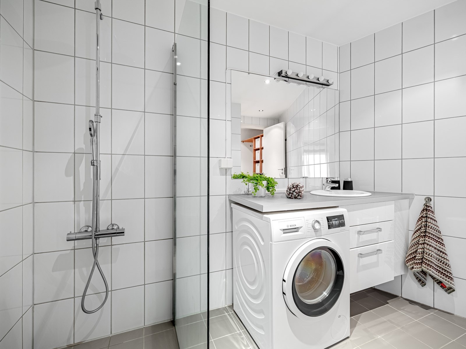 Pent, helfliset bad med varmekabler i gulv, downlights i himling og opplegg for vaskemaskin Galleribilde