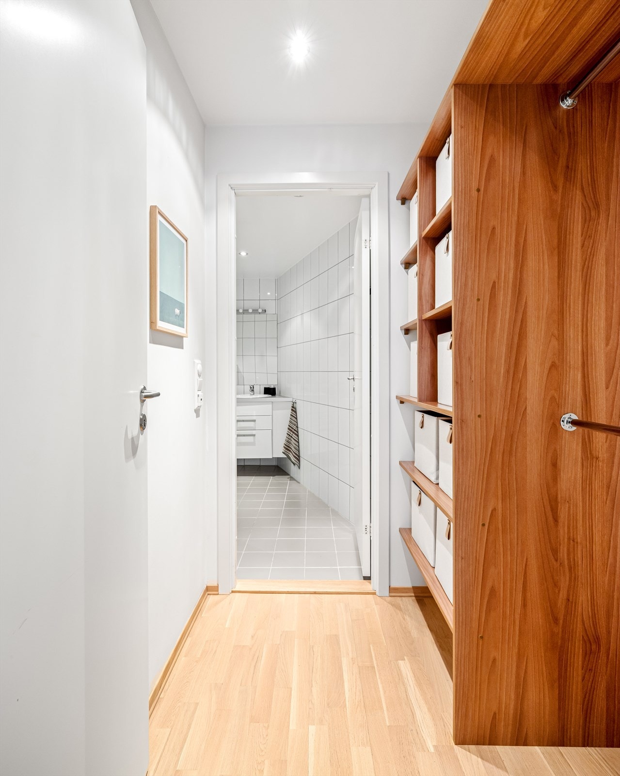 Mellomgang mellom stue og bad med praktisk plassbygd oppbevaringsløsning Galleribilde