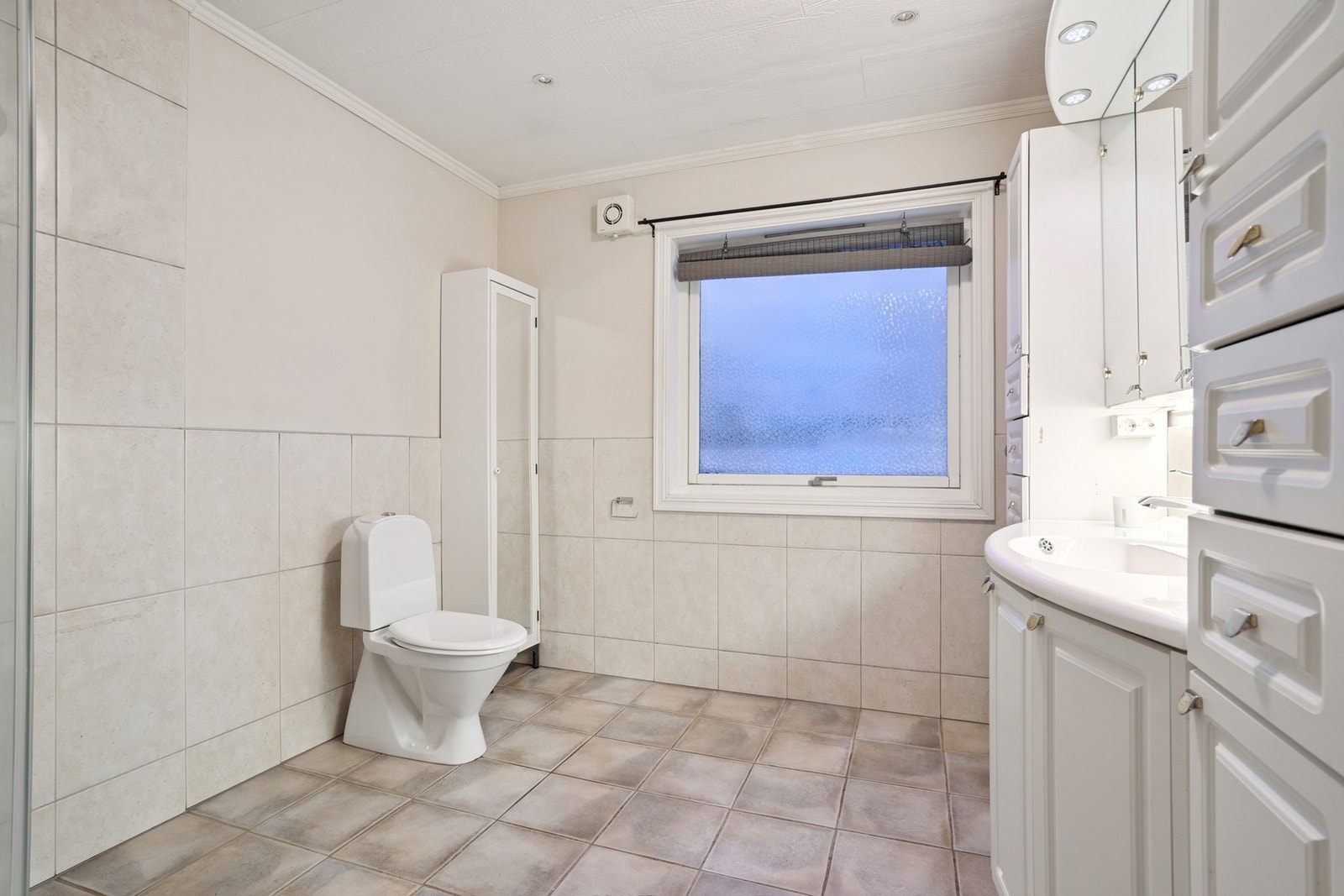 Innredet med toalett, vask, dusjkabinett og baderomsinnredning som byr på godt med oppbevaringsplass. Galleribilde