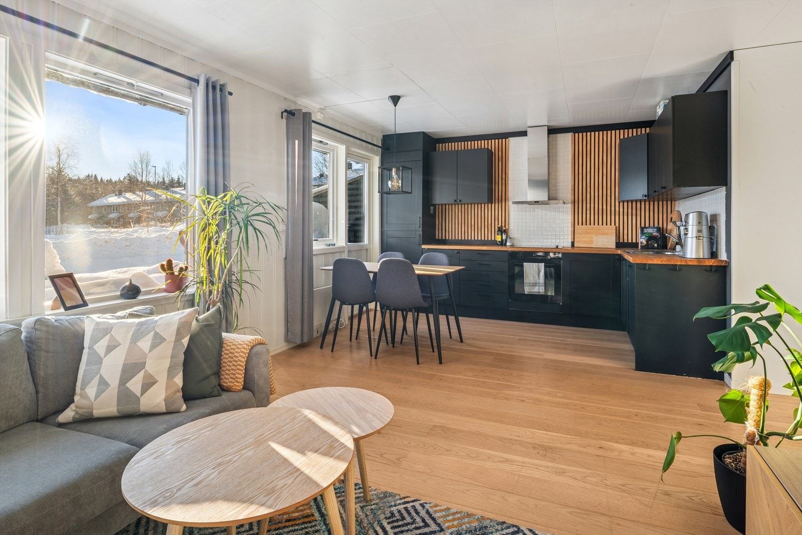 Moderne, åpen løsning mellom stue og kjøkken utgjør boligens sosiale samlingspunkt. Galleribilde