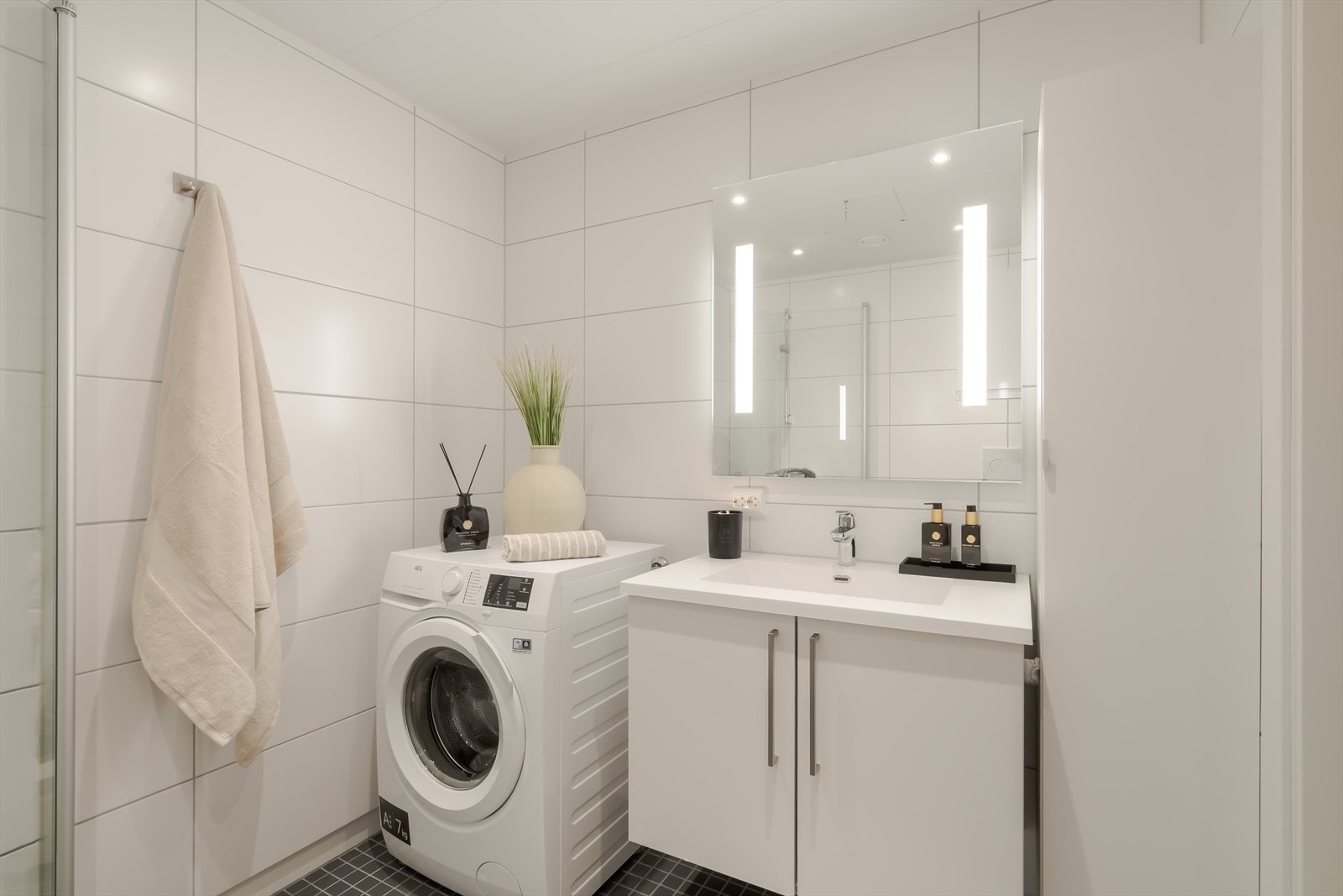 Det stilrene badet på 4,5 m² har helflisede overflater, og varmekabler i gulv som gir en varm og behagelig følelse. Galleribilde