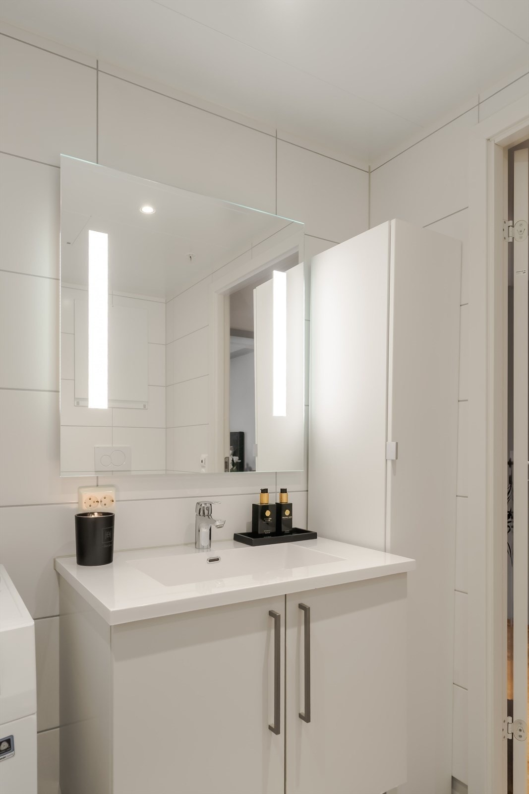 Badet har godt med oppbevaringsplass til blant annet håndduker og baderomsartikler, samt opplegg til vaskemaskin. Baderomsinnredningen er levert av HTH. Galleribilde