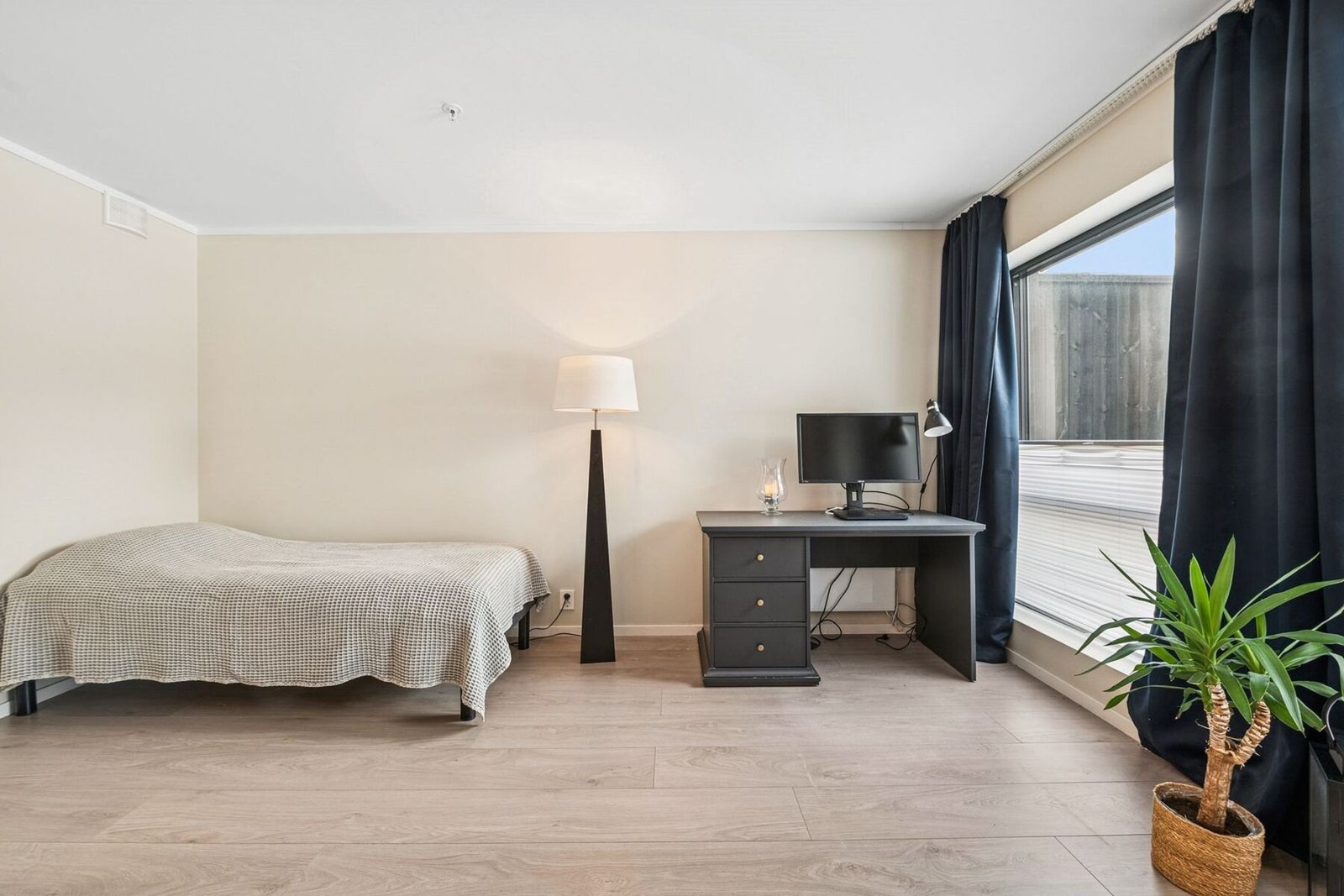 Romslig og moderne rom, møblert med seng og arbeidsplass. Store vinduer og lyse flater gir en luftig og behagelig atmosfære. Galleribilde