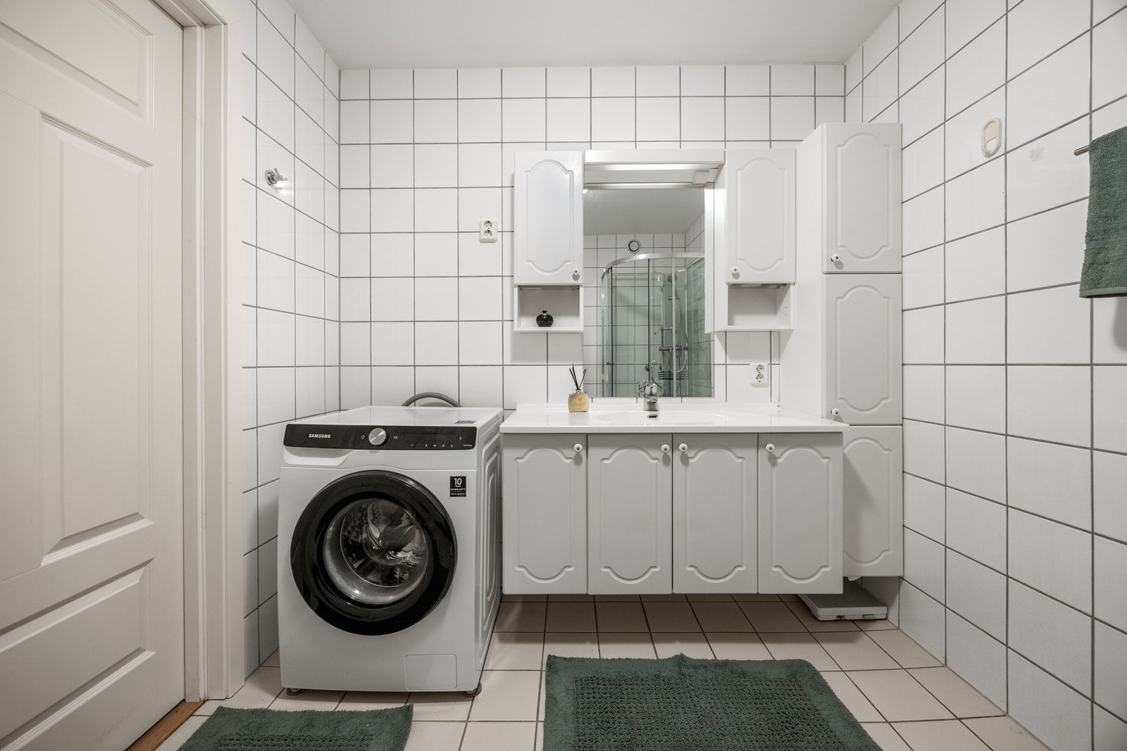 Badet er utstyrt med servantskap, WC, dusjkabinett, vaskemaskin og vaskeromsskap. Galleribilde