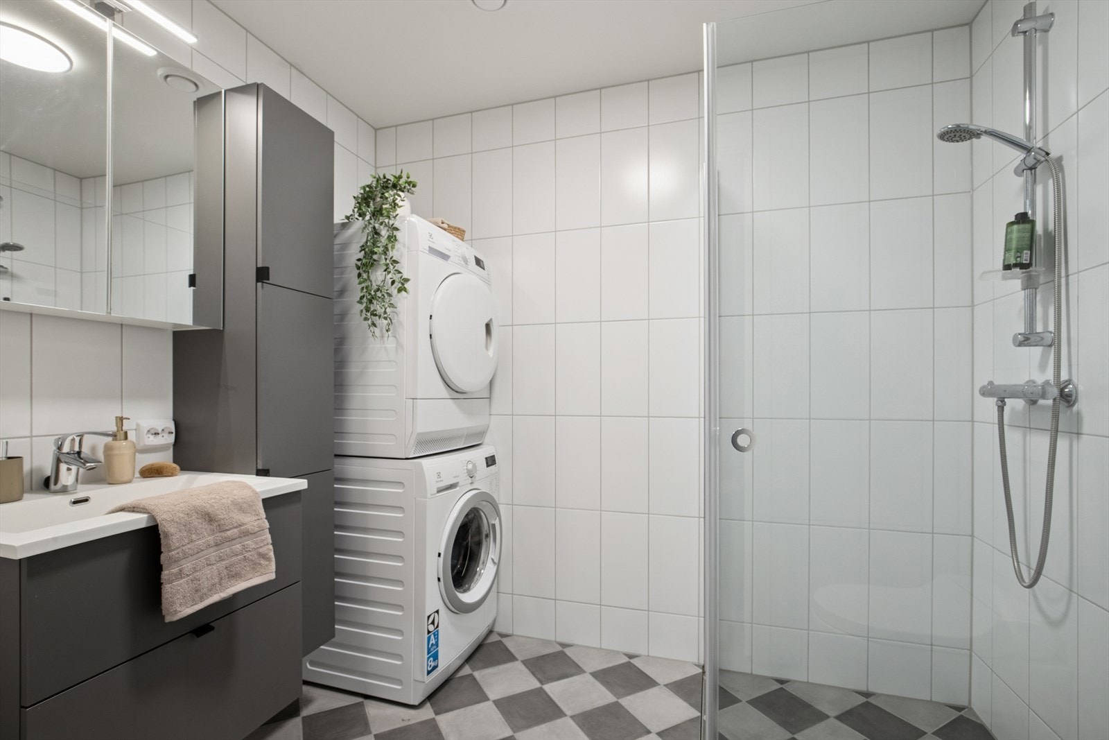 Badet er utstyrt med vegghengt toalett, dusjhjørne med innfellbare dører og opplegg for vaskesøyle. Galleribilde