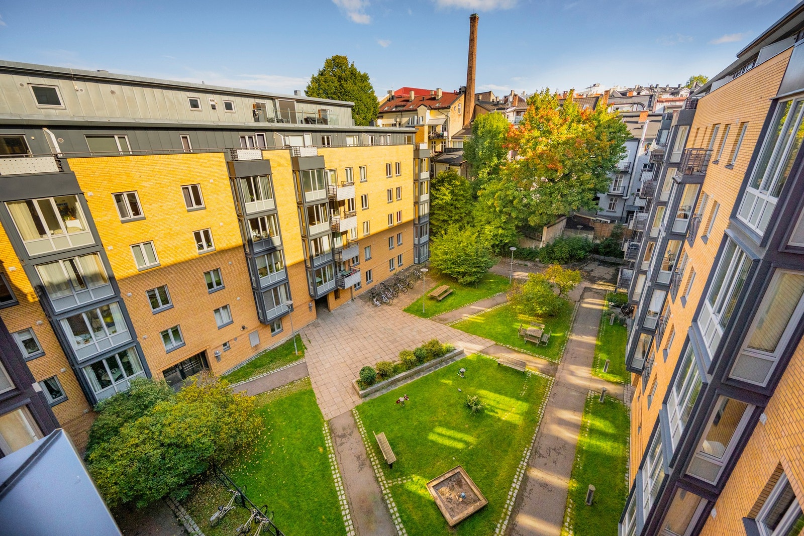 Bakgården har asfalterte internveier, plen, beplantning, sittegrupper m.m. Galleribilde
