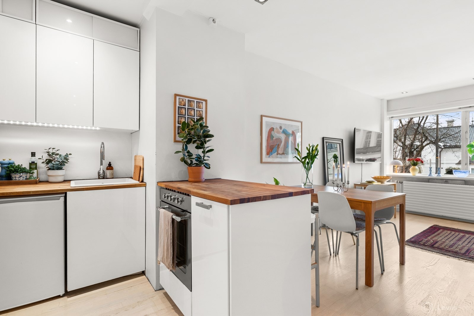 Stilrent kjøkken med glatte fronter og heltre benkeplate. Galleribilde