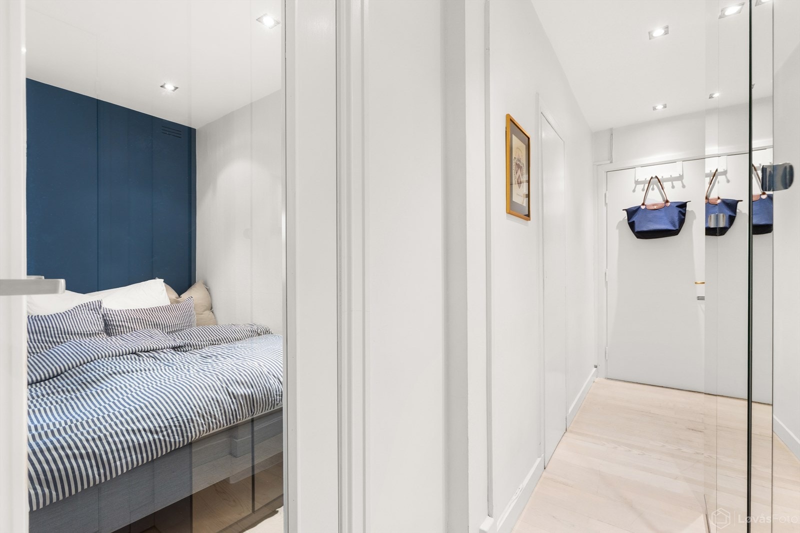 Innbydende entré med garderobeskap med speilfronter og glassdør inn til alkoven. Galleribilde