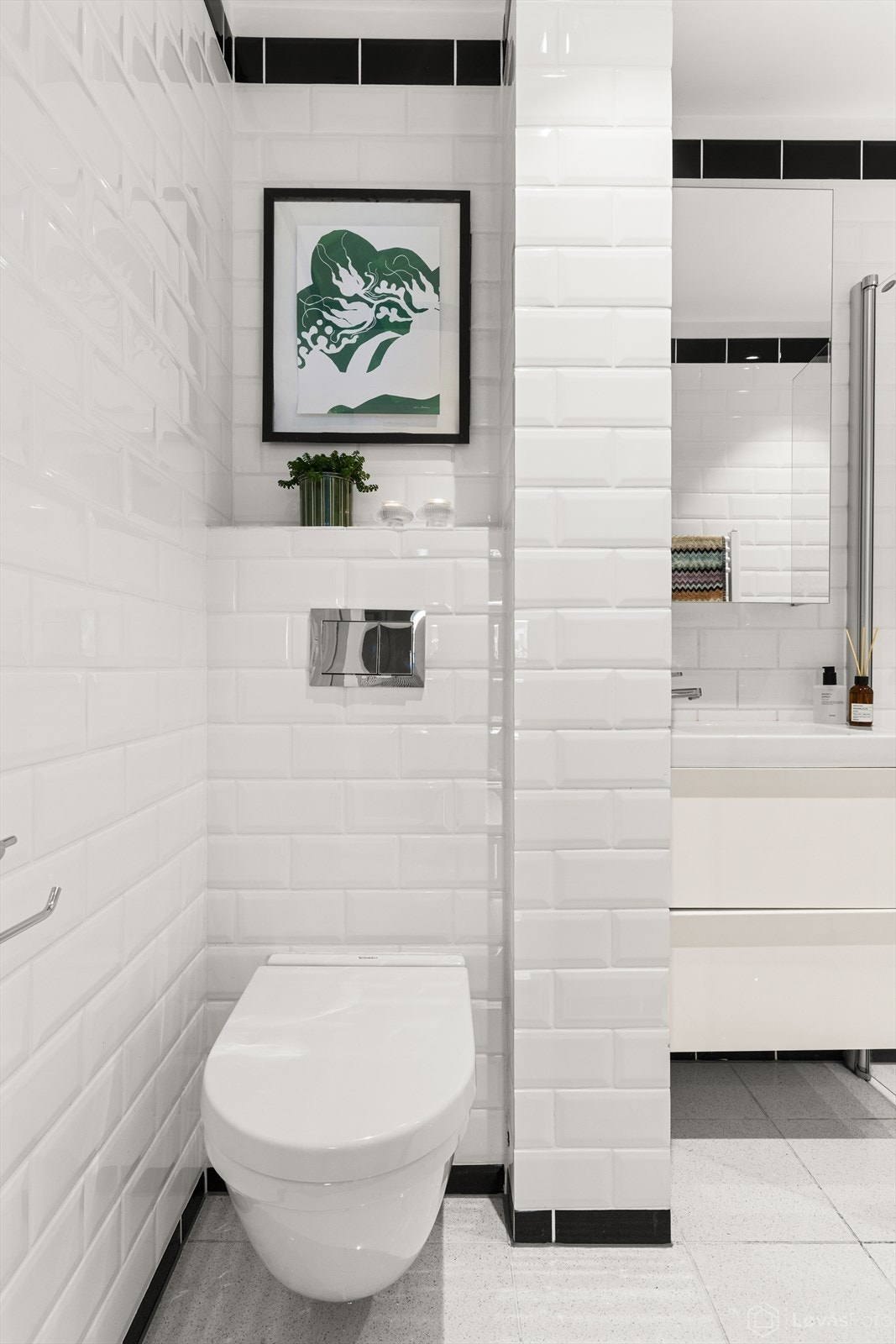 Badet er gjennomført med fliser på vegger og gulv, og har en praktisk nisjeløsning over toalettet. Galleribilde