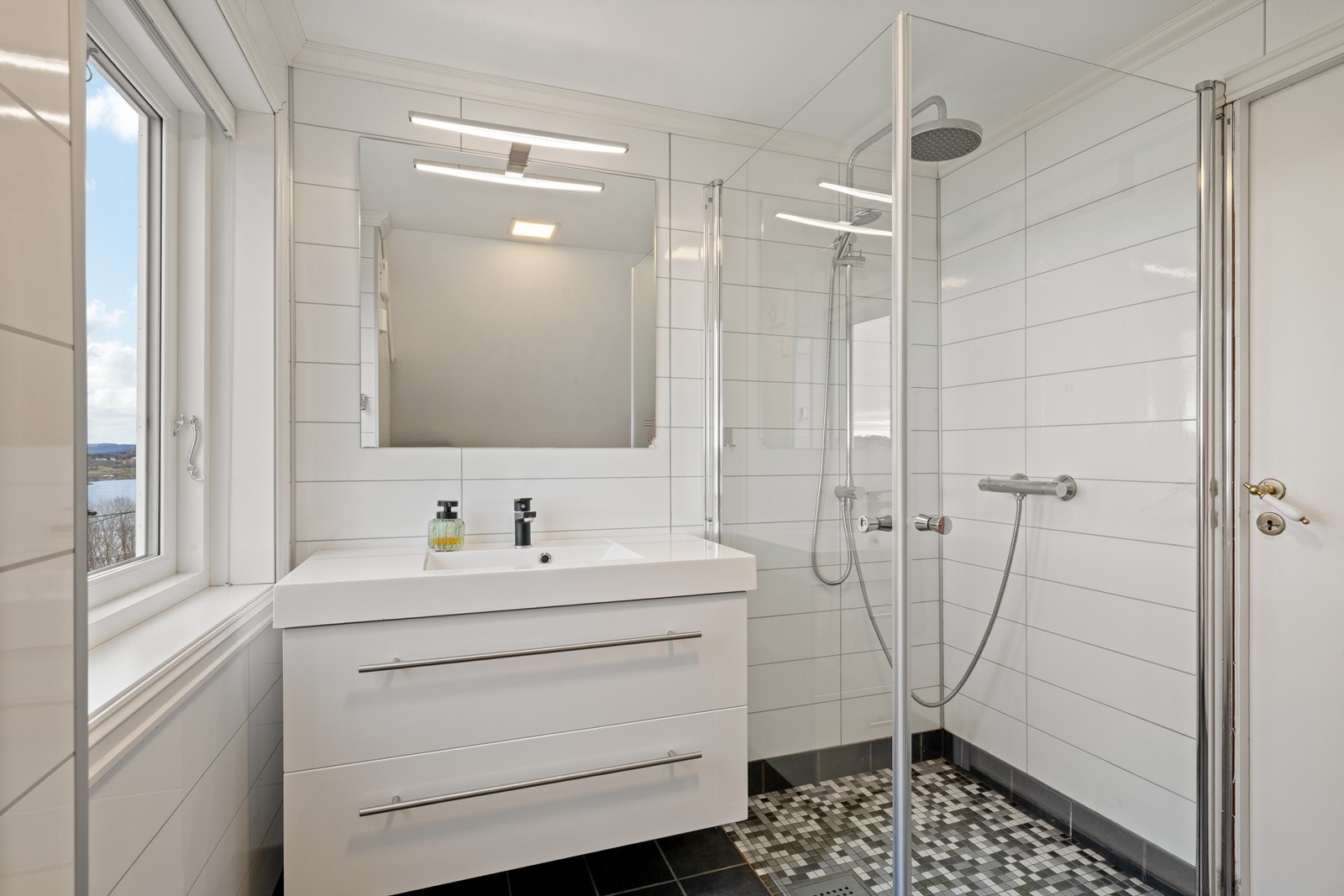 Baderommet har dusj, vaskeseksjon og veggmontert wc. Galleribilde