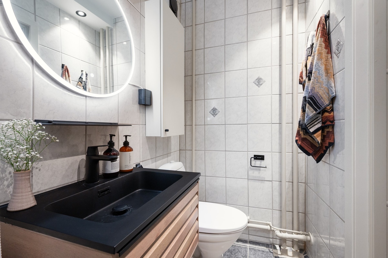 Flislagt baderom fra byggeår oppgradert med ny servant, servantskap, nye spotter og nytt speil i 2023. Galleribilde