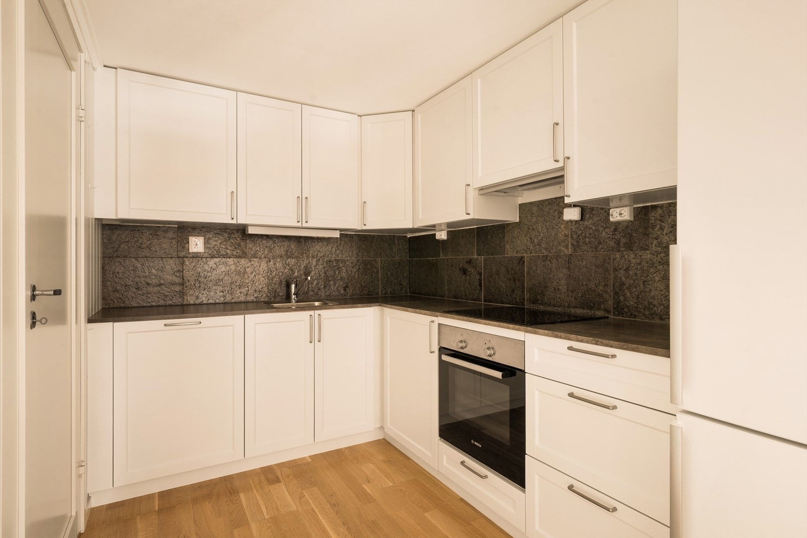 Kjøkkeninnredningen har lyse, profilerte fronter og laminat benkeplate med nedfelt kum. Galleribilde