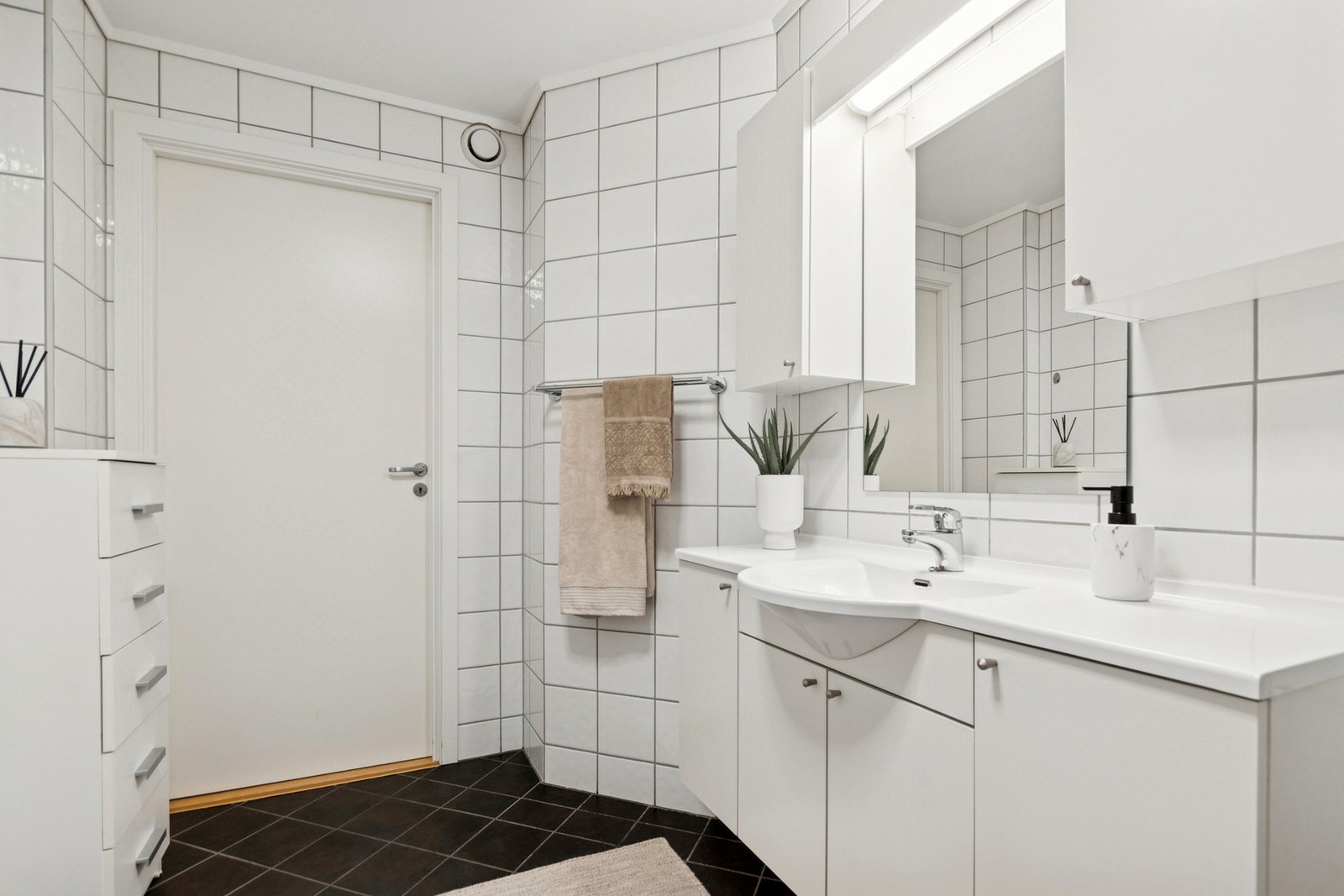 Rommet er innredet med nedfelt servant, toalett, dusjvegger/hjørne og opplegg for vaskemaskin. Galleribilde