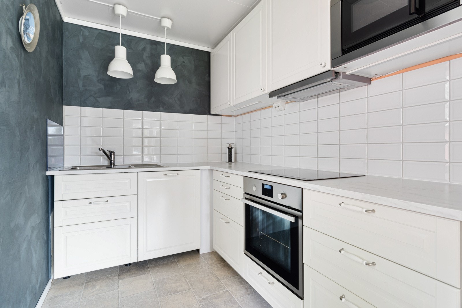 Kjøkken inneholder integrert oppvaskmaskin og microovn, med frittstående kjøl/fryseskap. Galleribilde